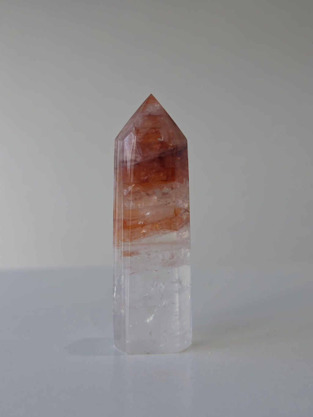 Luxury Fire Quartz Tower showcasing striking red inclusions and exceptional natural clarity. A premium statement piece curated by Stone and Bloom.