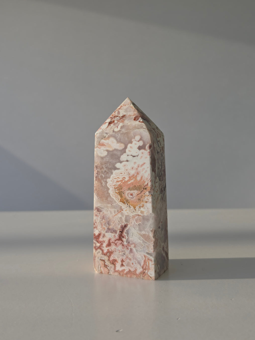 High quality Pink Mexican Lace Agate crystal tower with soft rose tones, natural lace patterns, and elegant statement décor styling by Stone and Bloom