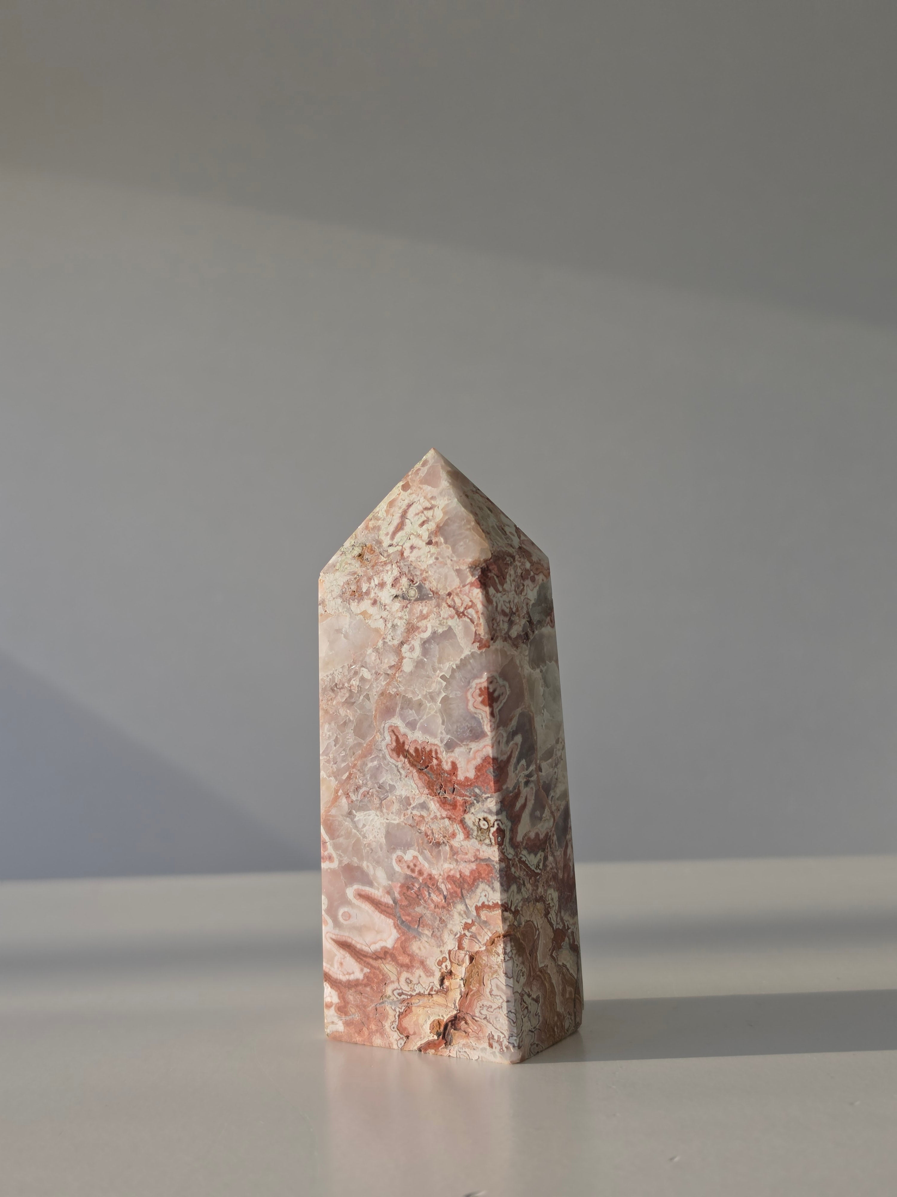 High quality Pink Mexican Lace Agate crystal tower with soft rose tones, natural lace patterns, and elegant statement décor styling by Stone and Bloom