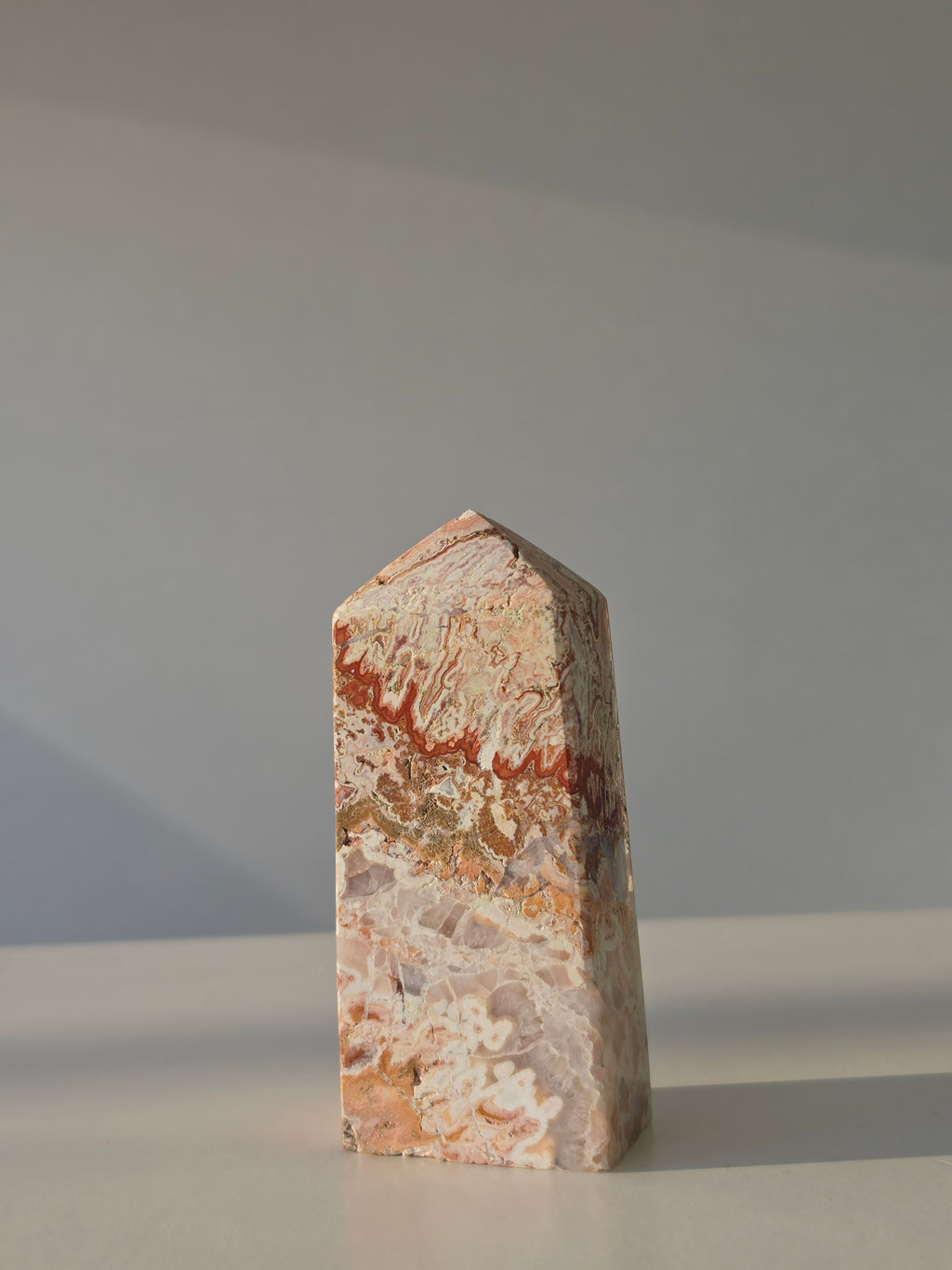 High quality Pink Mexican Lace Agate crystal tower with soft rose tones, natural lace patterns, and elegant statement décor styling by Stone and Bloom