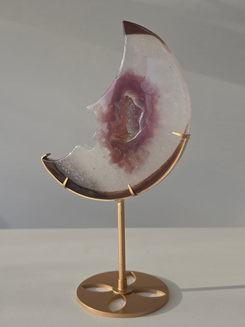Luxury Pink Agate Druzy Moon on gold stand featuring soft ivory and mauve banding, sparkling crystal centre, and elegant celestial styling curated by Stone and Bloom