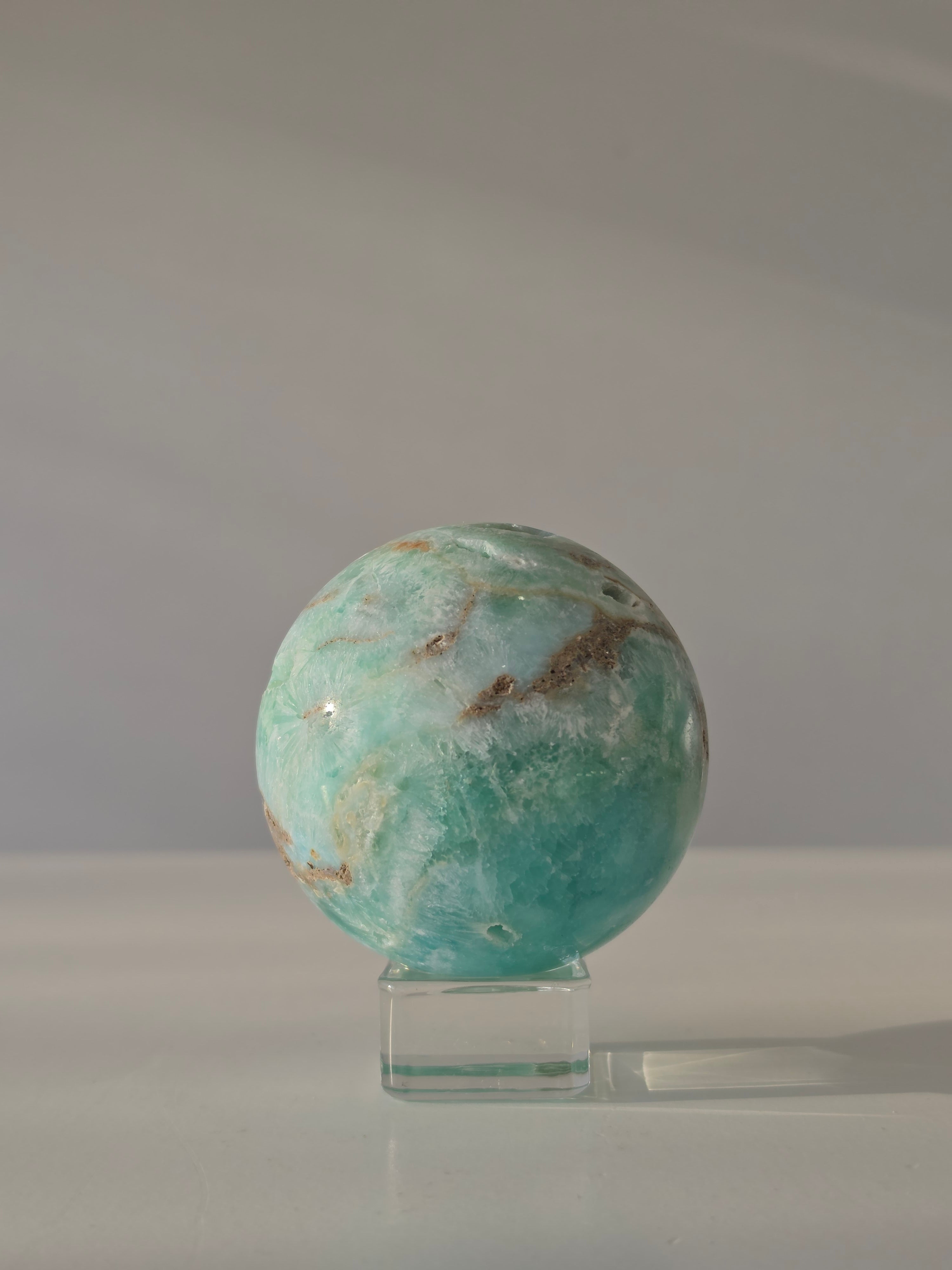 Luxury sparkling Hemimorphite Sphere by Stone and Bloom featuring sky-blue crystal formations, shimmering druzy texture, and premium polished craftsmanship.