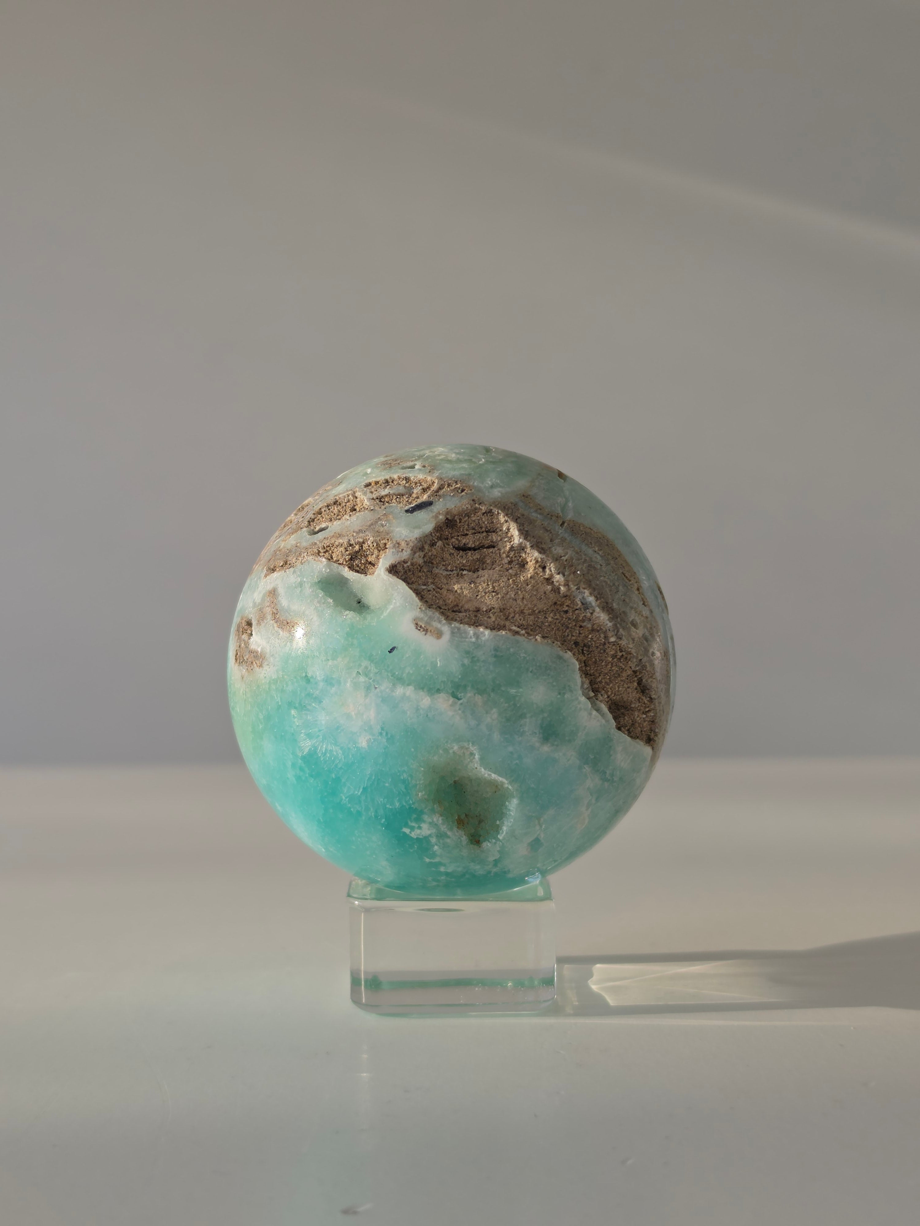 Luxury sparkling Hemimorphite Sphere by Stone and Bloom featuring sky-blue crystal formations, shimmering druzy texture, and premium polished craftsmanship.