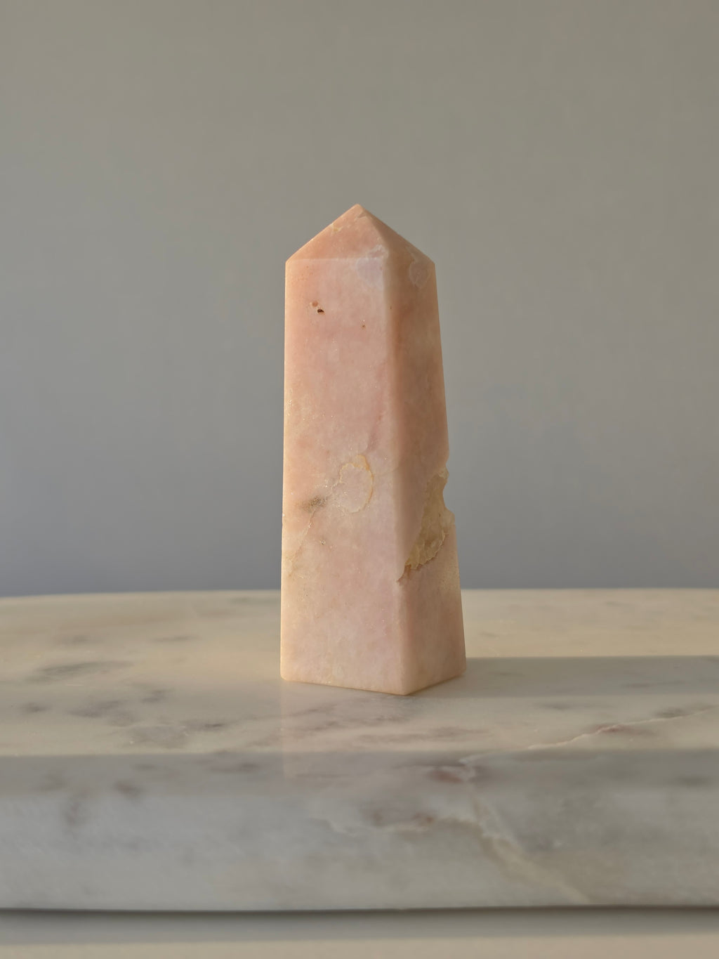High-grade Pink Amethyst crystal tower featuring soft blush pink tones, sparkling druzy crystal formations, natural crystalline pockets, and polished geometric facets, photographed in natural light.