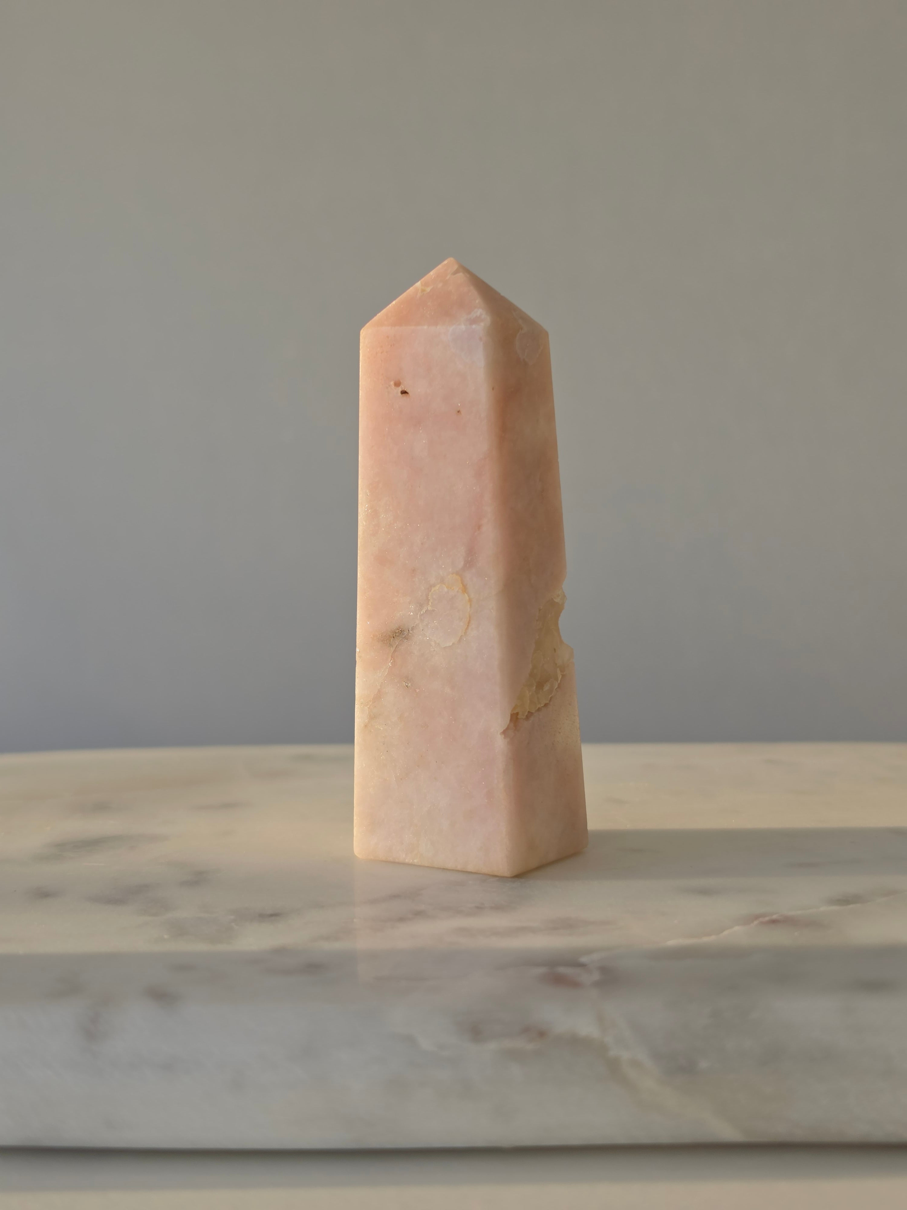 High-grade Pink Amethyst crystal tower featuring soft blush pink tones, sparkling druzy crystal formations, natural crystalline pockets, and polished geometric facets, photographed in natural light.