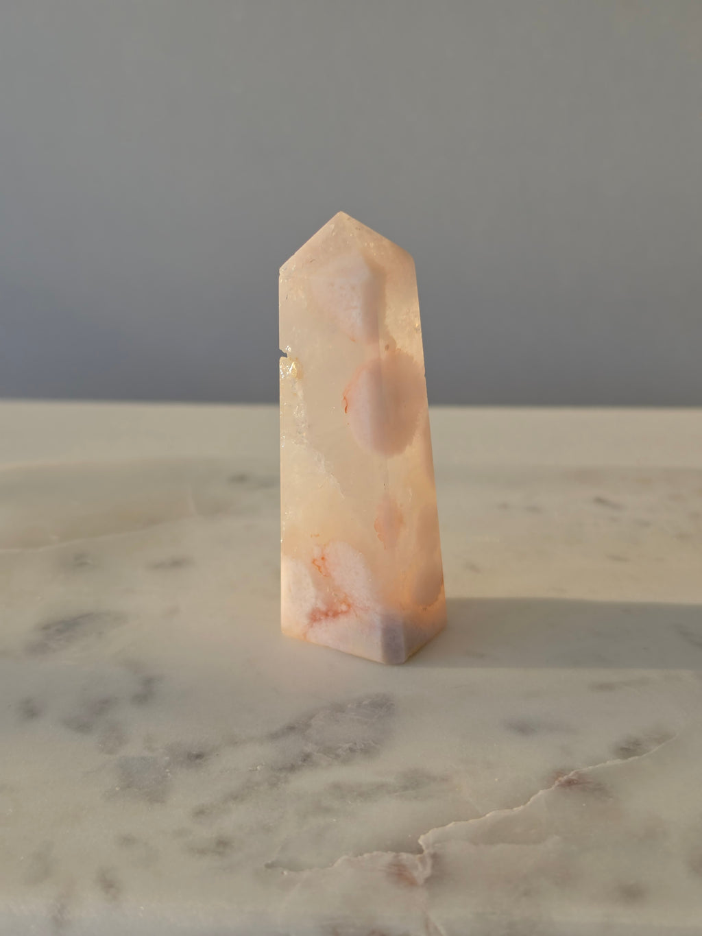 High-grade Pink Amethyst crystal tower featuring soft blush pink tones, sparkling druzy crystal formations, natural crystalline pockets, and polished geometric facets, photographed in natural light.