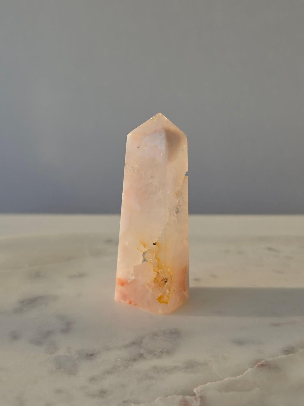 High-grade Pink Amethyst crystal tower featuring soft blush pink tones, sparkling druzy crystal formations, natural crystalline pockets, and polished geometric facets, photographed in natural light.