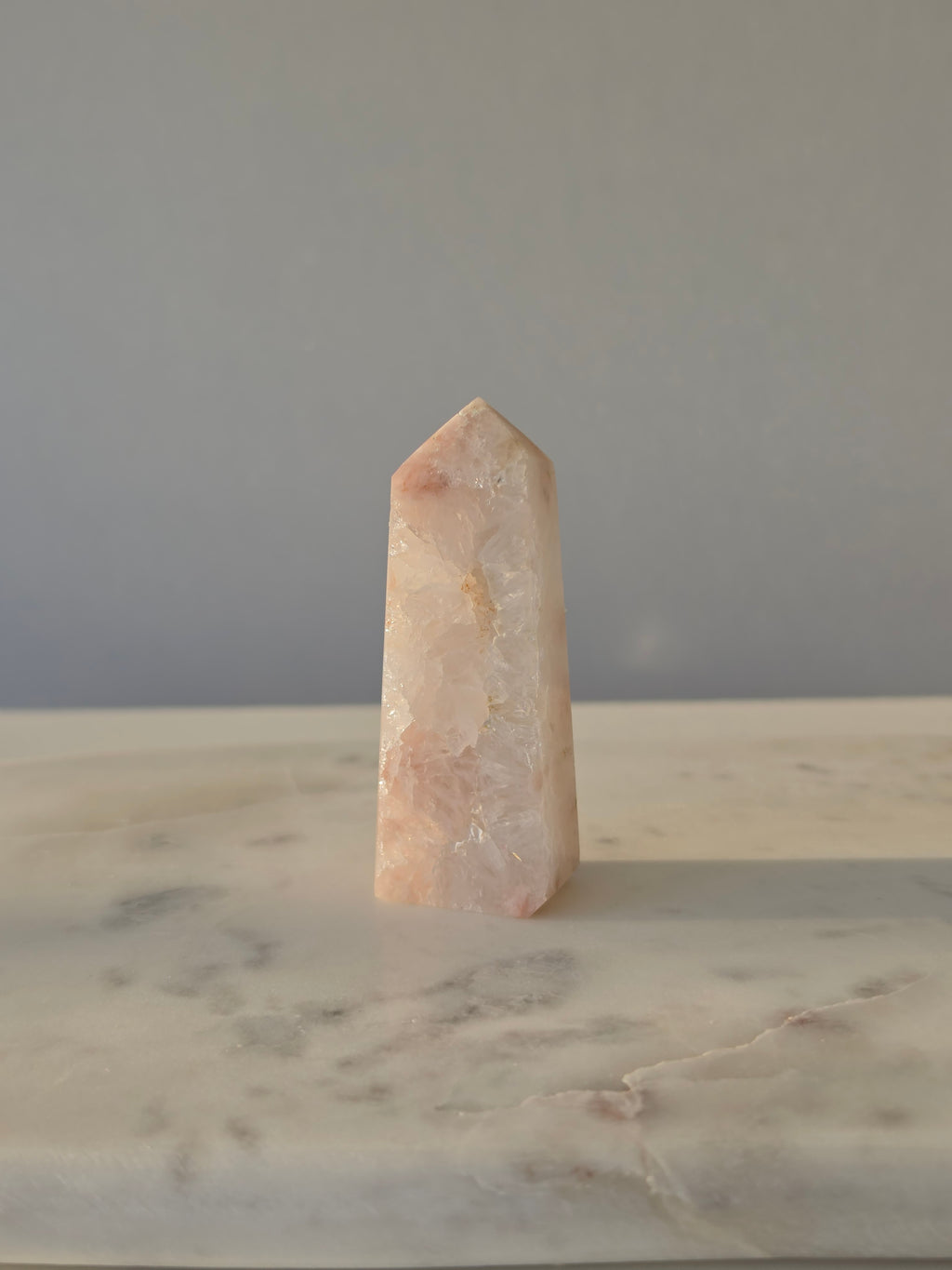 High-grade Pink Amethyst crystal tower featuring soft blush pink tones, sparkling druzy crystal formations, natural crystalline pockets, and polished geometric facets, photographed in natural light.