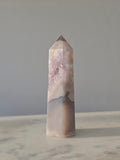 High-grade Purple Amethyst druzy tower featuring soft lavender crystal formations, sparkling druzy pocket, natural agate banding, and polished geometric facets, photographed in natural light.