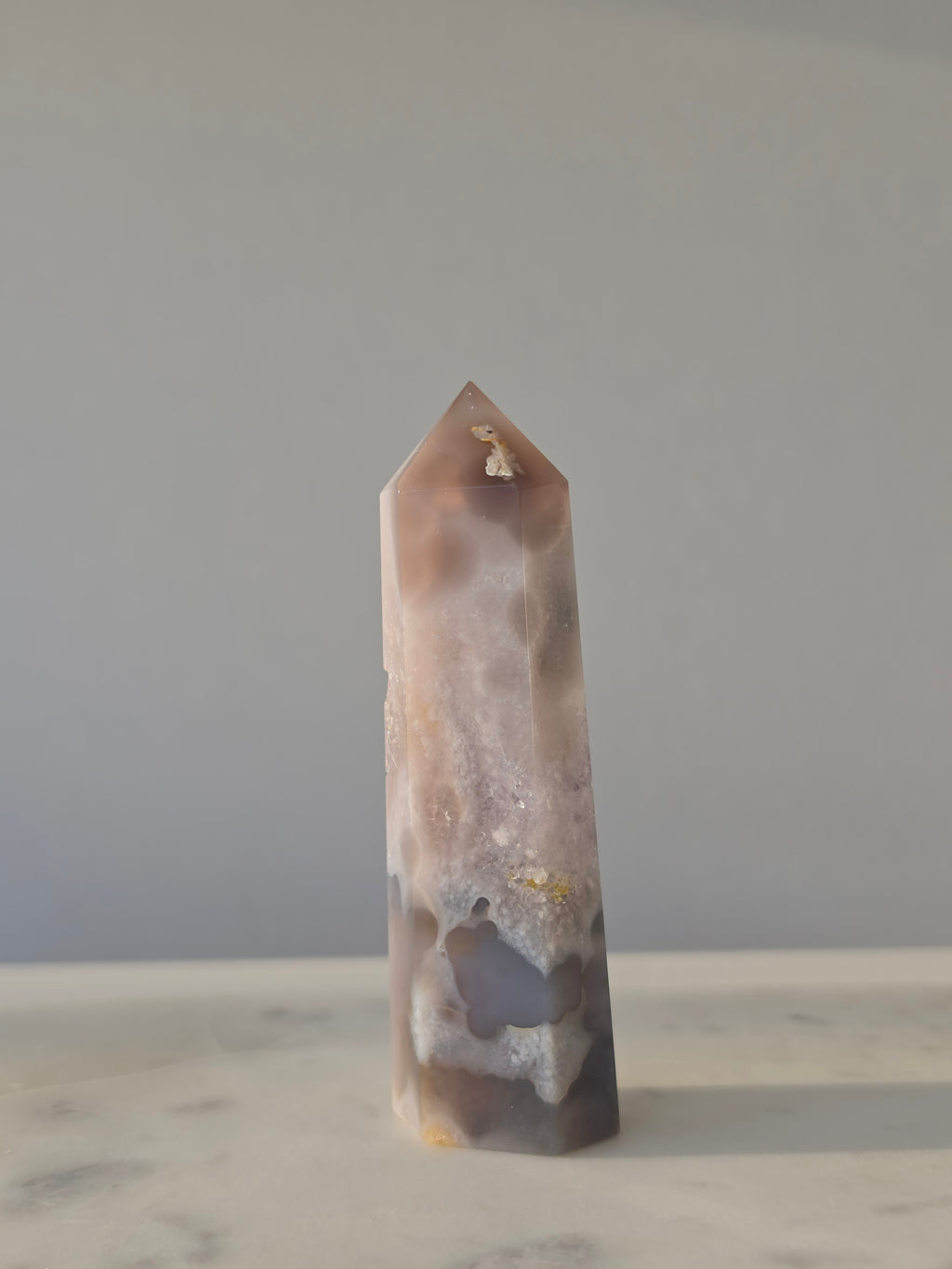 High-grade Purple Amethyst druzy tower featuring soft lavender crystal formations, sparkling druzy pocket, natural agate banding, and polished geometric facets, photographed in natural light.