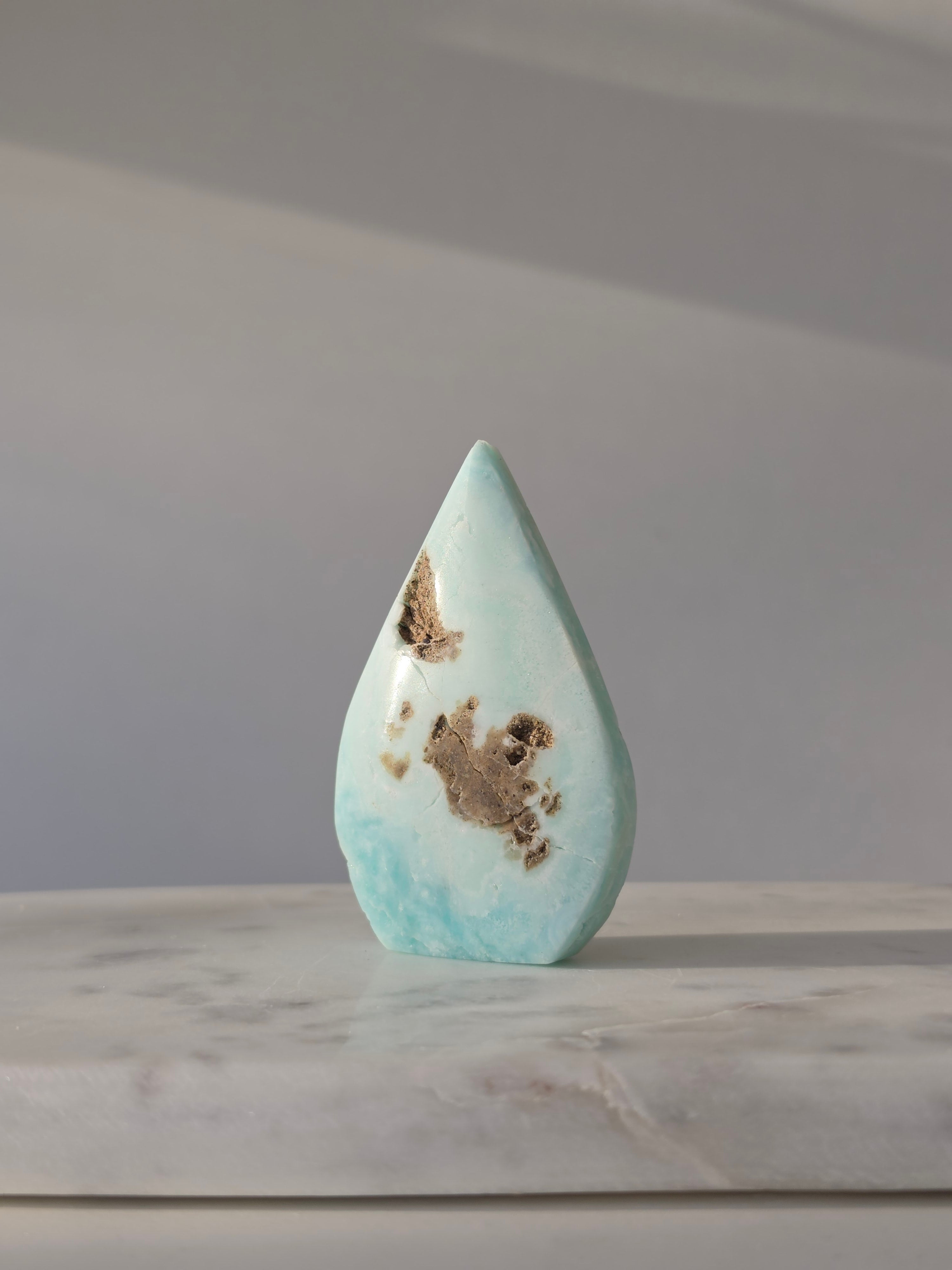 High-grade Hemimorphite flame featuring oceanic aqua and seafoam green banding, natural sculptural cavities, and flowing mineral patterns, photographed in natural light and curated by Stone and Bloom.