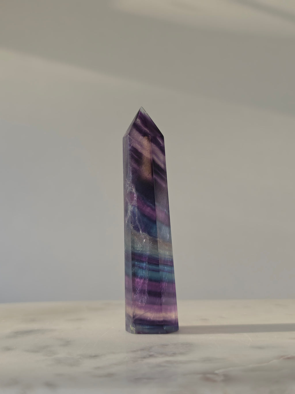 High-grade Rainbow Fluorite crystal tower featuring translucent aqua, mint green, and violet banding with natural internal rainbows and exceptional clarity, curated by Stone and Bloom.