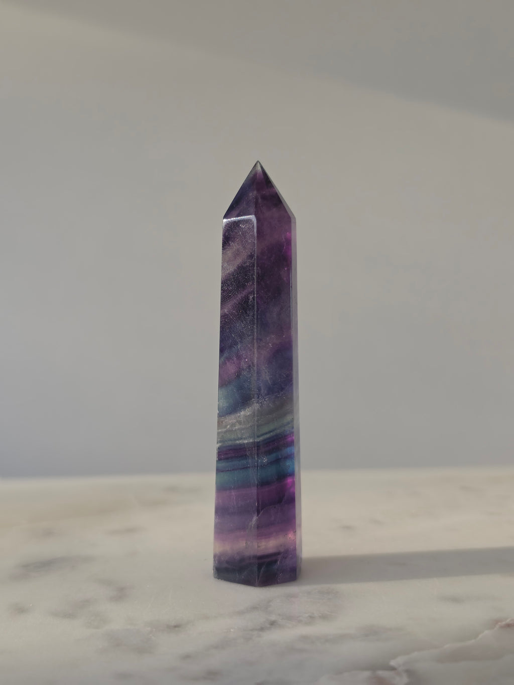 High-grade Rainbow Fluorite crystal tower featuring translucent aqua, mint green, and violet banding with natural internal rainbows and exceptional clarity, curated by Stone and Bloom.