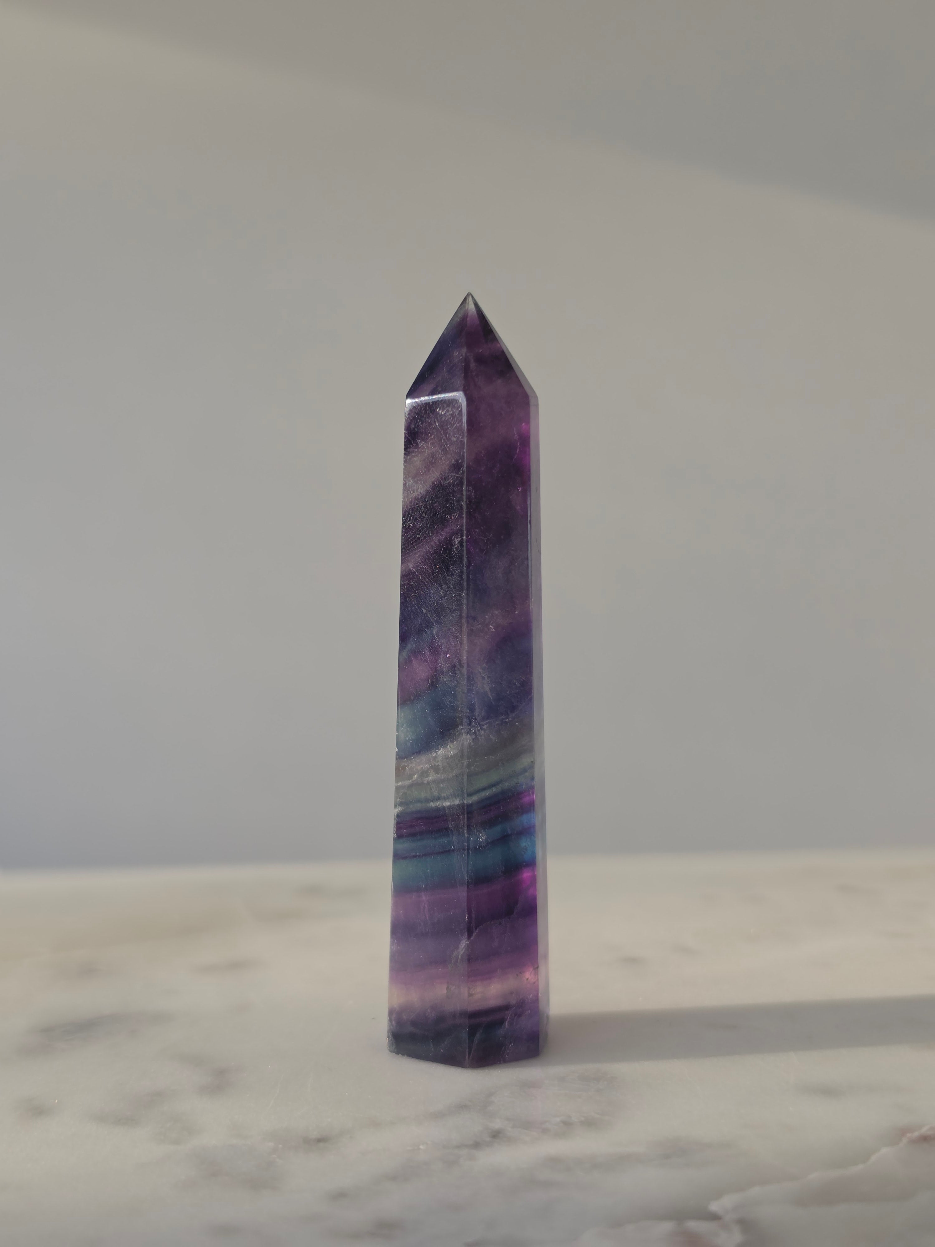 High-grade Rainbow Fluorite crystal tower featuring translucent aqua, mint green, and violet banding with natural internal rainbows and exceptional clarity, curated by Stone and Bloom.