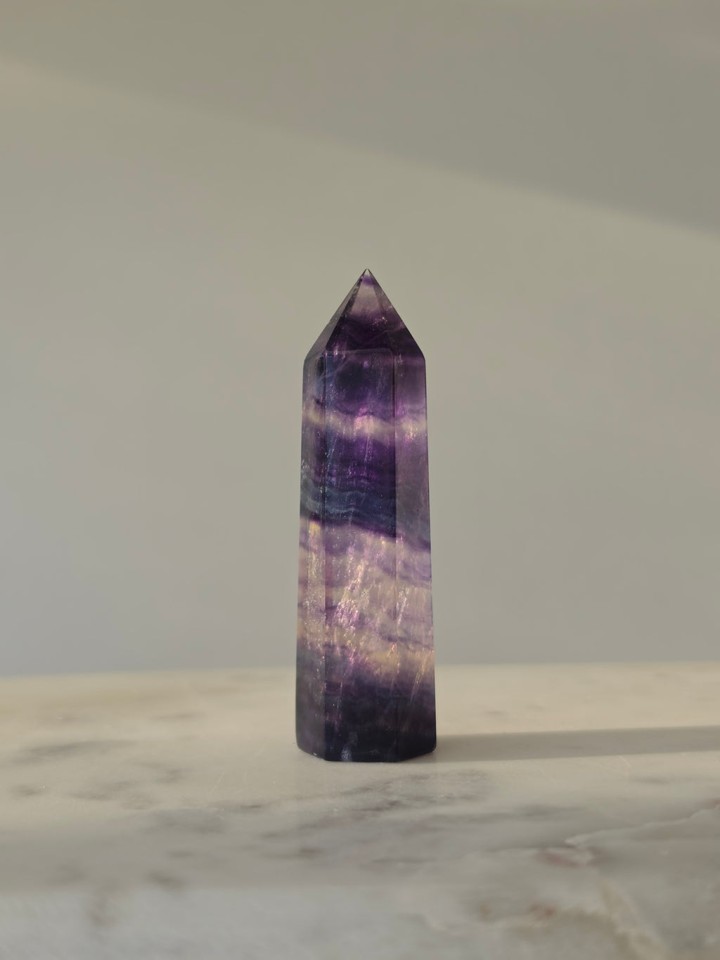 High-grade Rainbow Fluorite crystal tower featuring translucent aqua, mint green, and violet banding with natural internal rainbows and exceptional clarity, curated by Stone and Bloom.