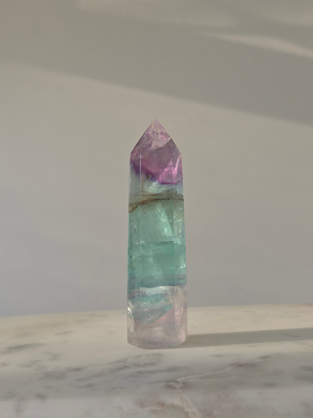 High-grade Rainbow Fluorite crystal tower featuring translucent aqua, mint green, and violet banding with natural internal rainbows and exceptional clarity, curated by Stone and Bloom.