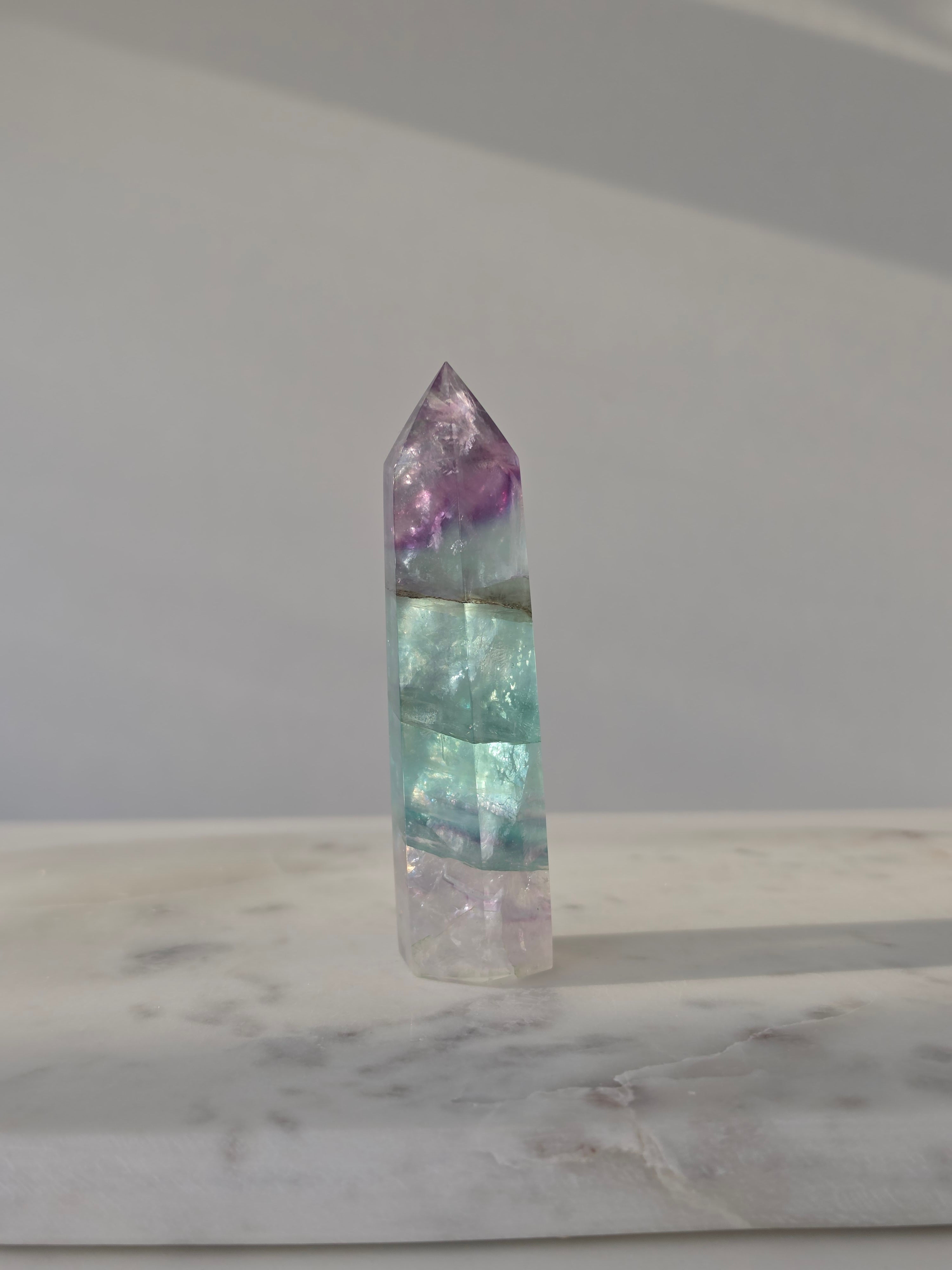 High-grade Rainbow Fluorite crystal tower featuring translucent aqua, mint green, and violet banding with natural internal rainbows and exceptional clarity, curated by Stone and Bloom.