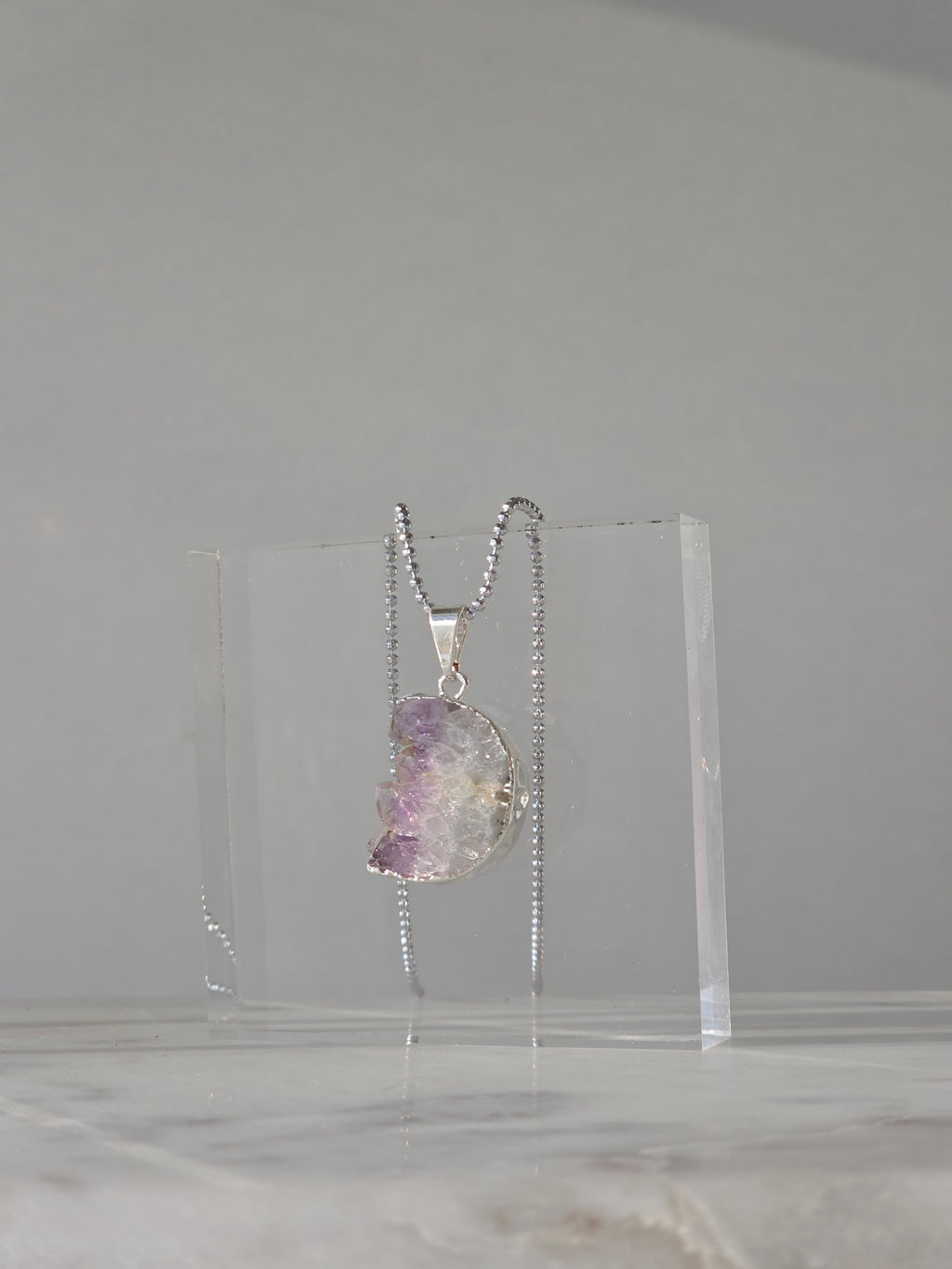 Natural Amethyst Slice Moon Pendant, raw crystal druzy pendant in a silver-plated setting from the Stone & Bloom Raw Luxe Collection.
