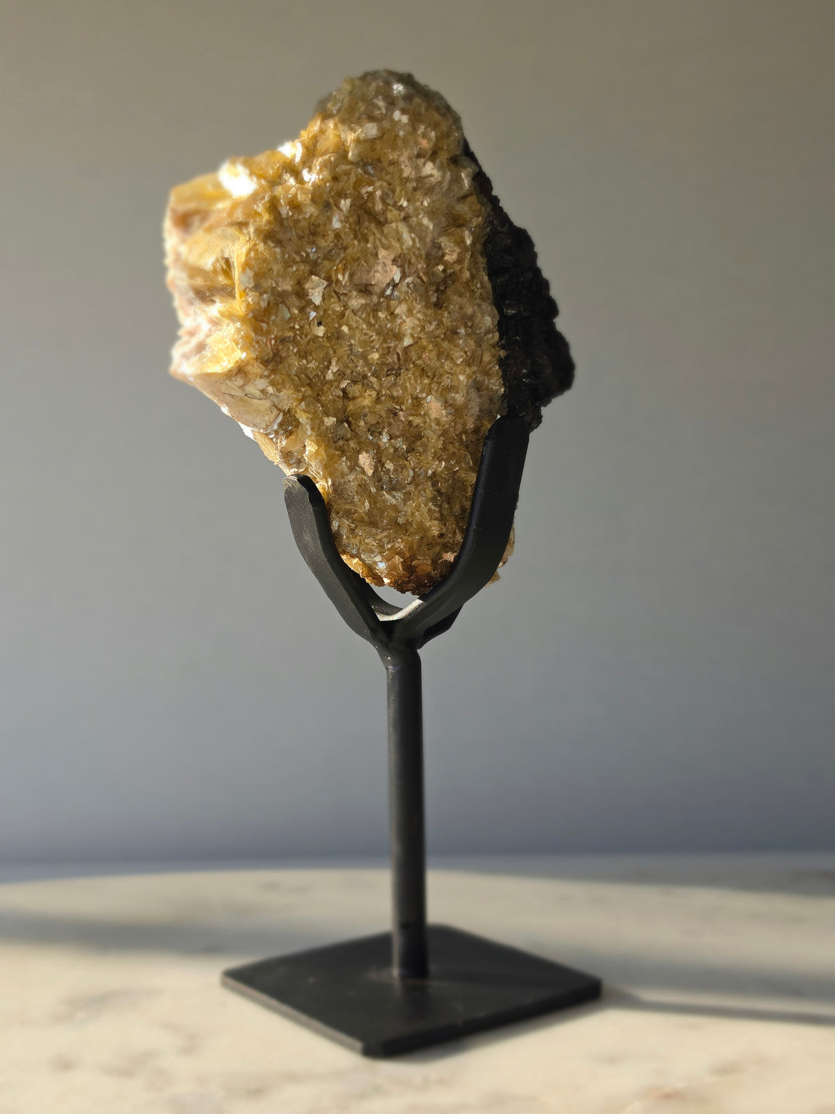Golden Mica and Black Tourmaline mineral specimen with white Albite matrix displayed on a black metal stand, weighing 460g and measuring 16cm high including stand.