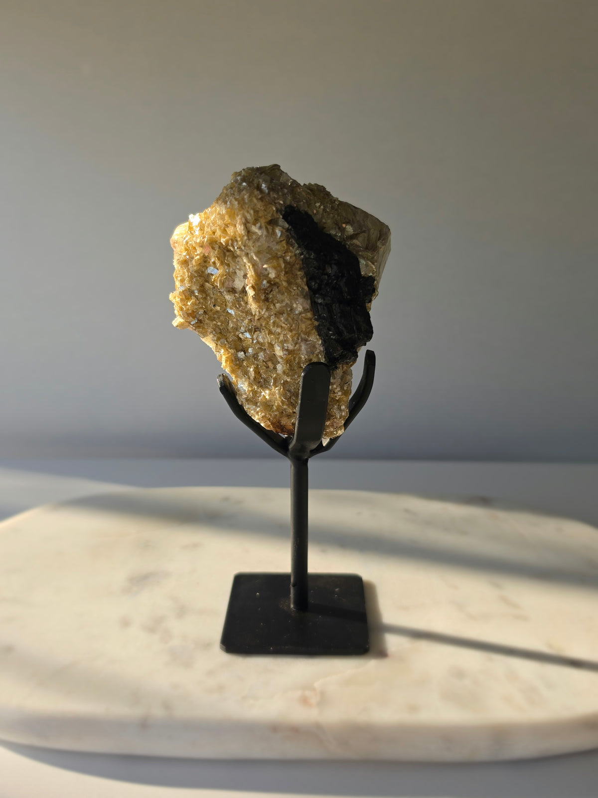 Golden Mica and Black Tourmaline mineral specimen with white Albite matrix displayed on a black metal stand, weighing 460g and measuring 16cm high including stand.