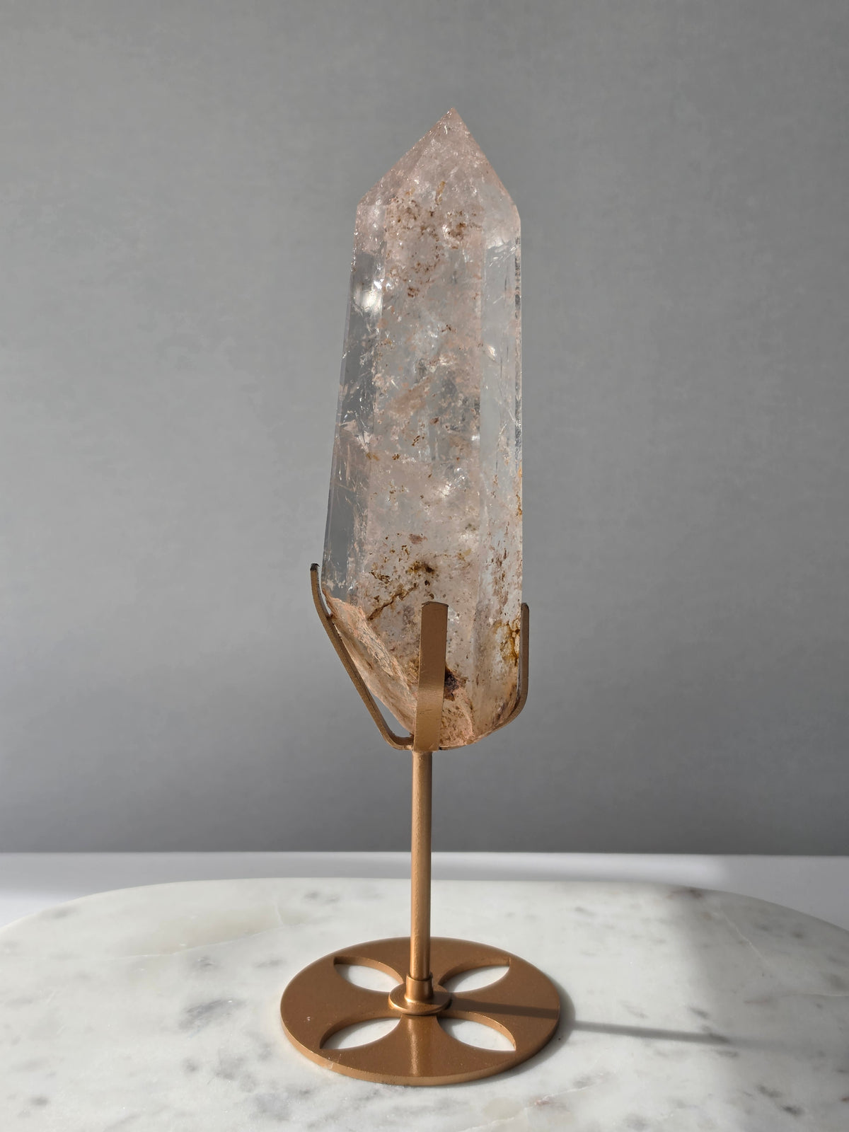 High-grade Nepalese Pink Himalayan Quartz statement point, 626g and 25.5cm tall, featuring soft blush pink tones, natural inclusions and translucent crystal formations, displayed on a gold stand by Stone & Bloom Co.