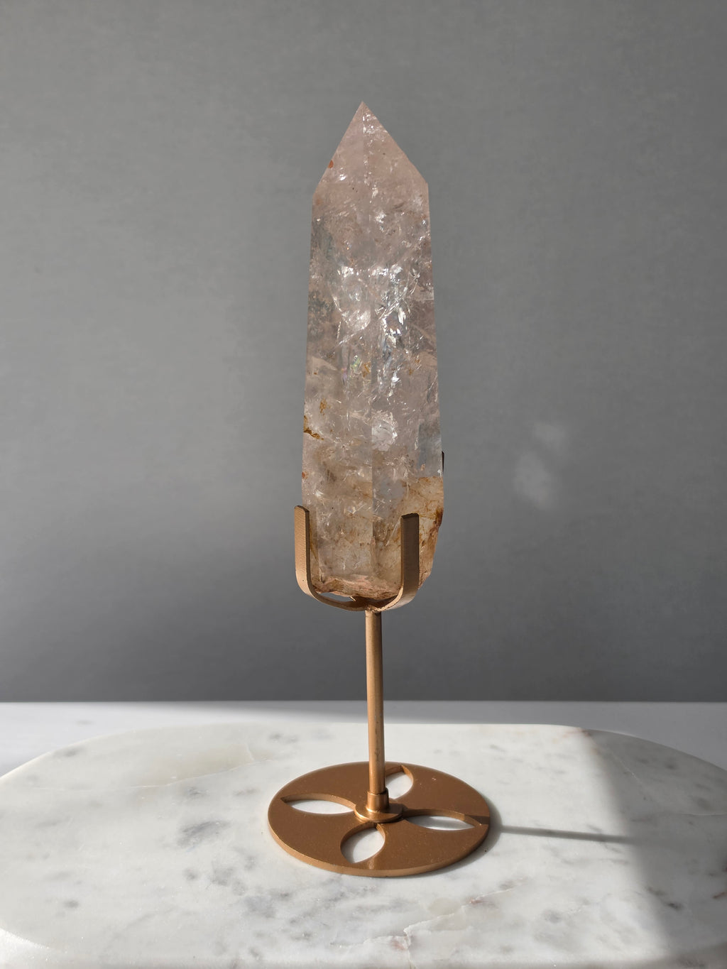 High-grade Nepalese Pink Himalayan Quartz statement point, 626g and 25.5cm tall, featuring soft blush pink tones, natural inclusions and translucent crystal formations, displayed on a gold stand by Stone & Bloom Co.