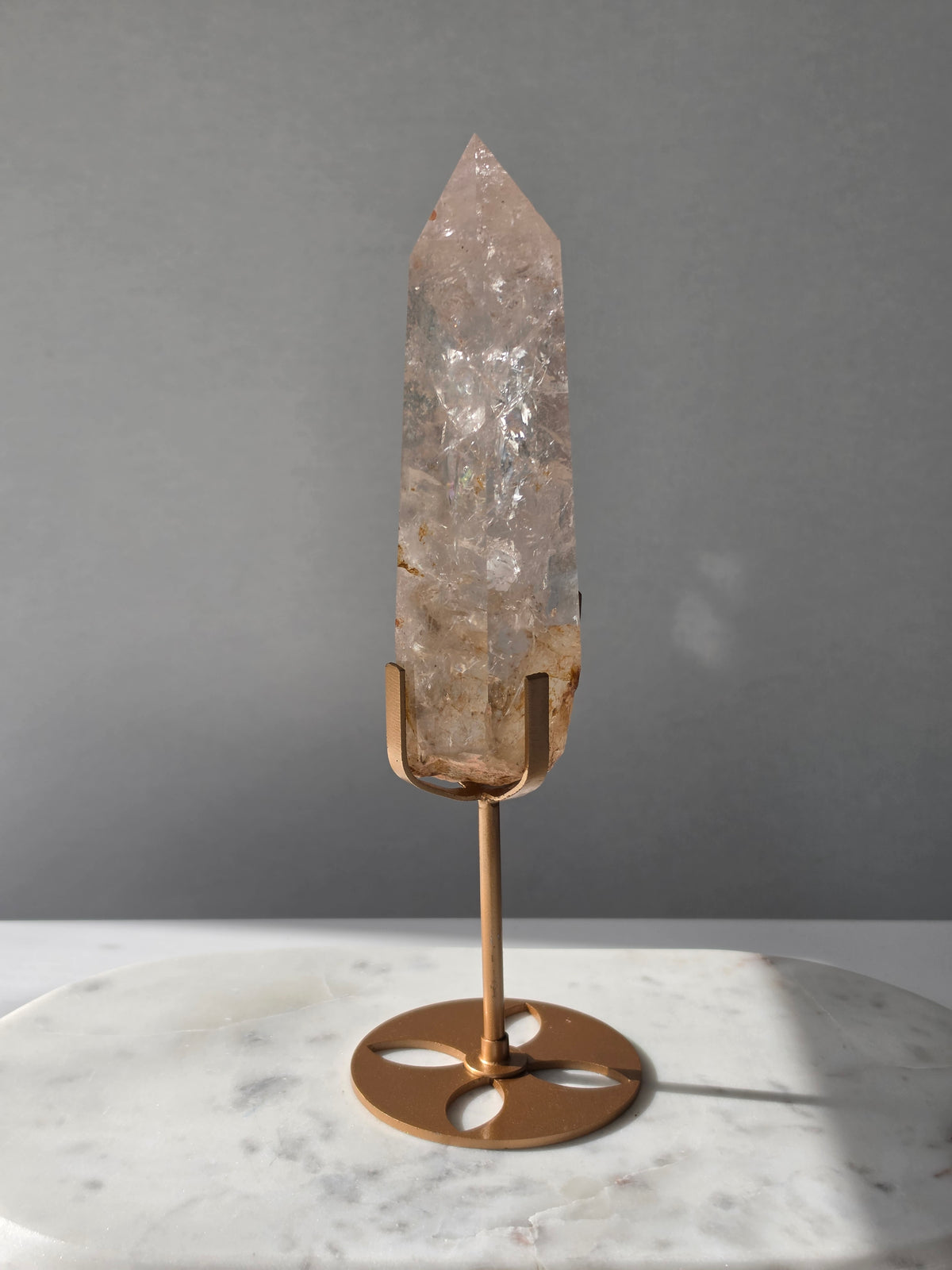 High-grade Nepalese Pink Himalayan Quartz statement point, 626g and 25.5cm tall, featuring soft blush pink tones, natural inclusions and translucent crystal formations, displayed on a gold stand by Stone & Bloom Co.