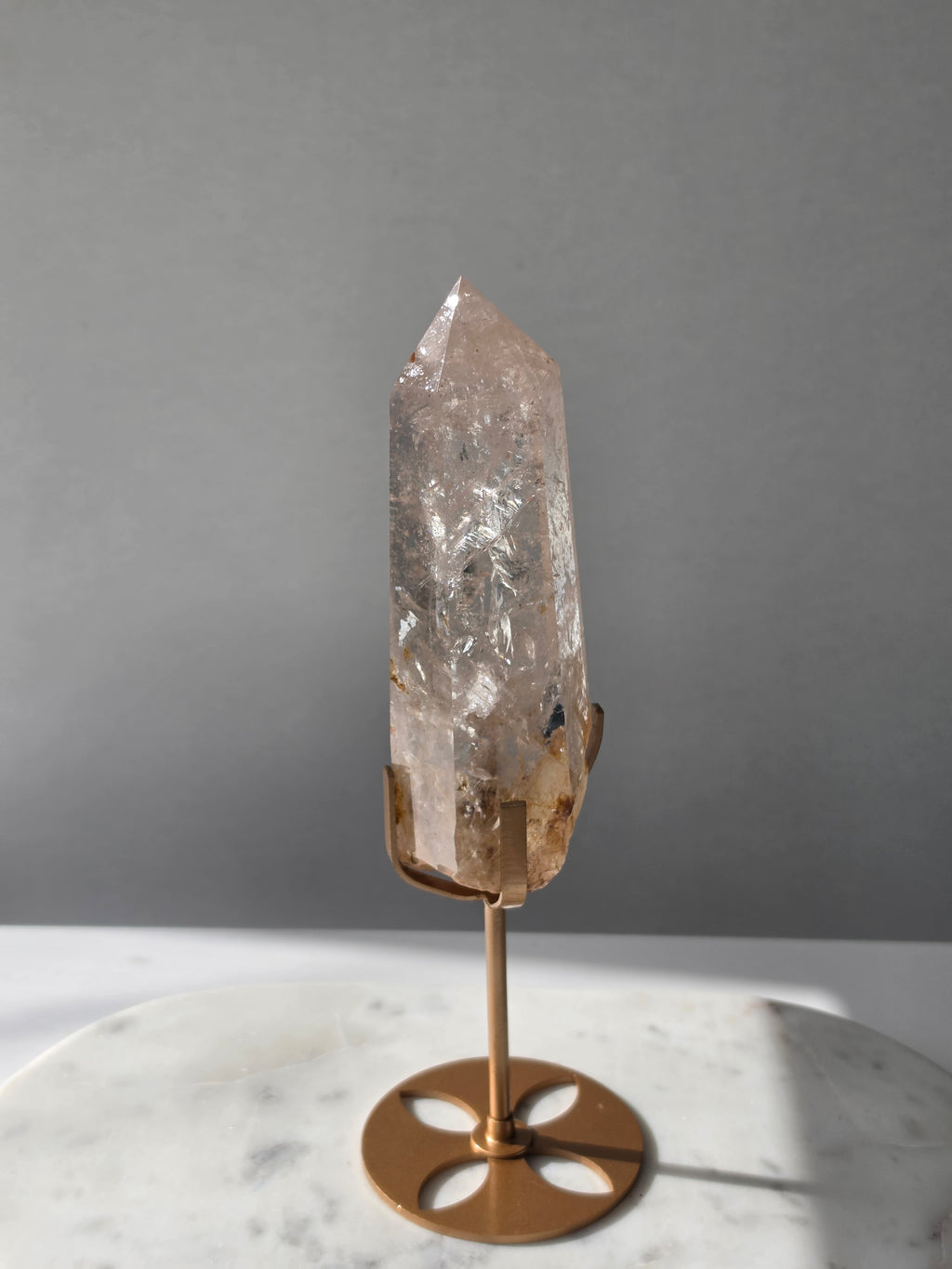 High-grade Nepalese Pink Himalayan Quartz statement point, 626g and 25.5cm tall, featuring soft blush pink tones, natural inclusions and translucent crystal formations, displayed on a gold stand by Stone & Bloom Co.