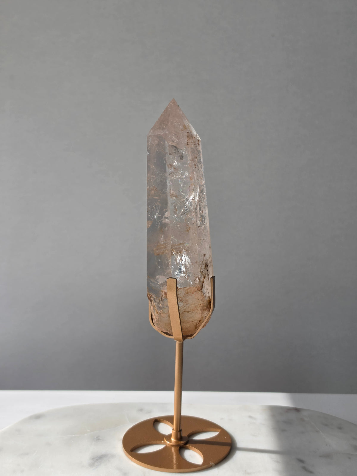 High-grade Nepalese Pink Himalayan Quartz statement point, 626g and 25.5cm tall, featuring soft blush pink tones, natural inclusions and translucent crystal formations, displayed on a gold stand by Stone & Bloom Co.