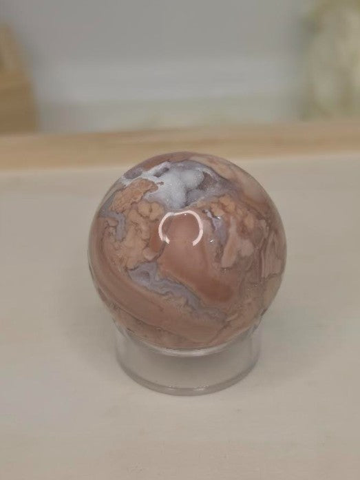 Luxury Candy Agate Sphere by Stone and Bloom featuring soft blush pink and white natural patterns with sparkling druzy,
Candy Agate Sphere
Crystal Sphere
Luxury Crystal Décor
Statement Crystal Piece
Stone and Bloom