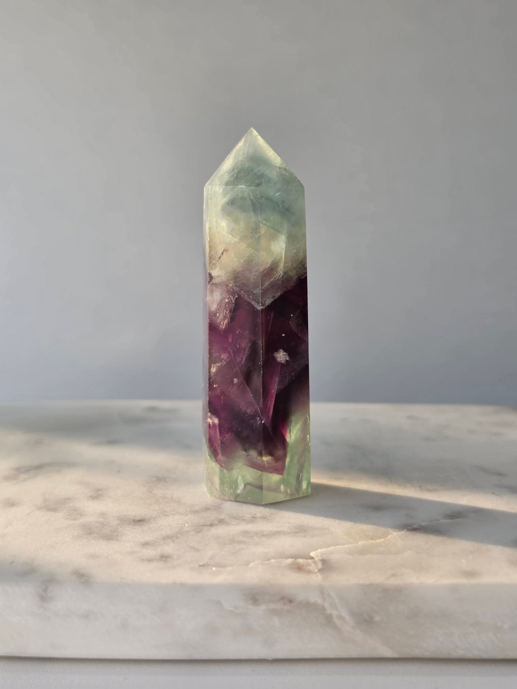 Natural Fluorite crystal point with deep purple and light green colour zoning, transparent polished finish and unique internal formations