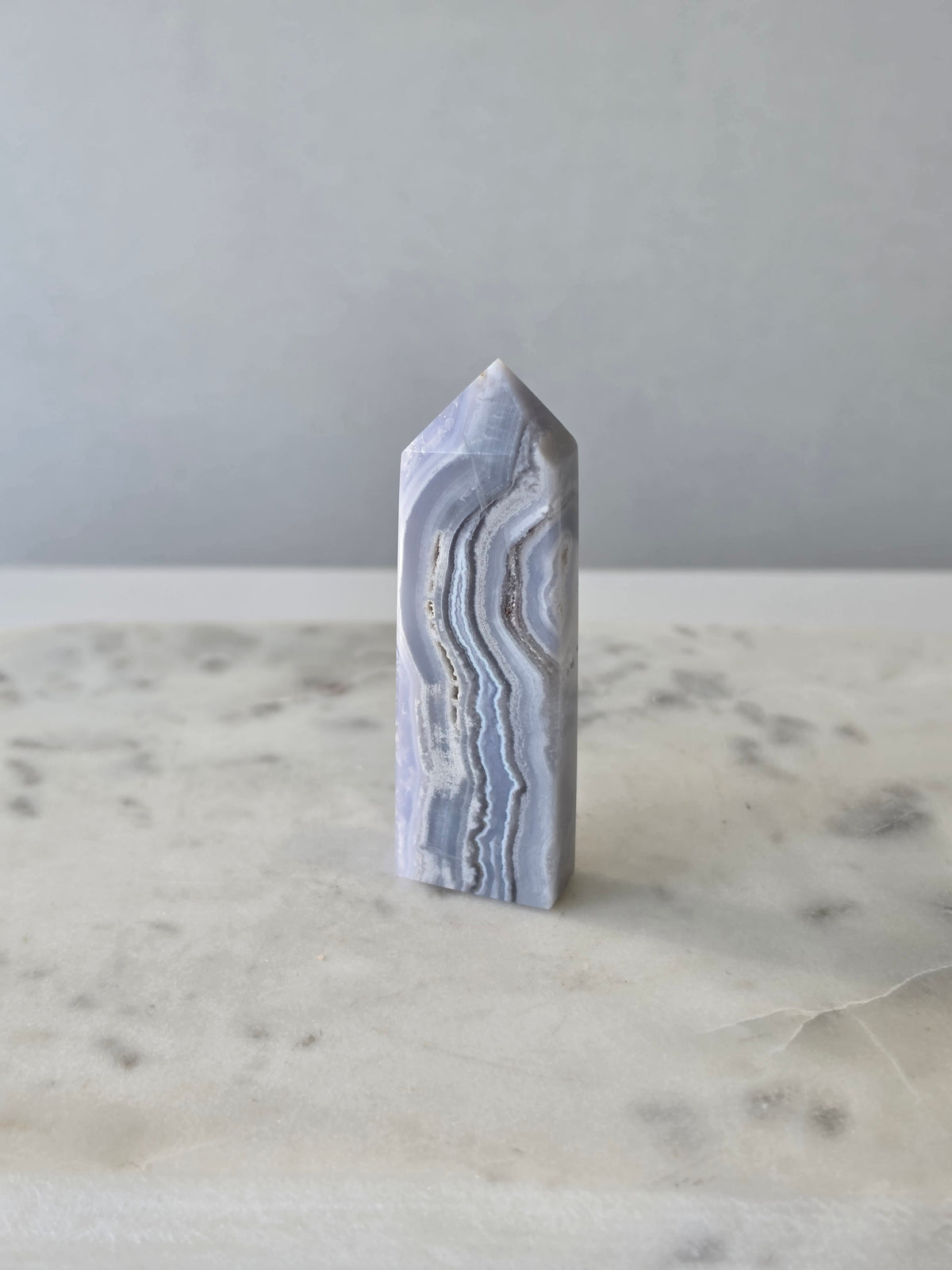 Natural Blue Lace Agate crystal point with soft blue and white banding, polished finish and unique natural formations