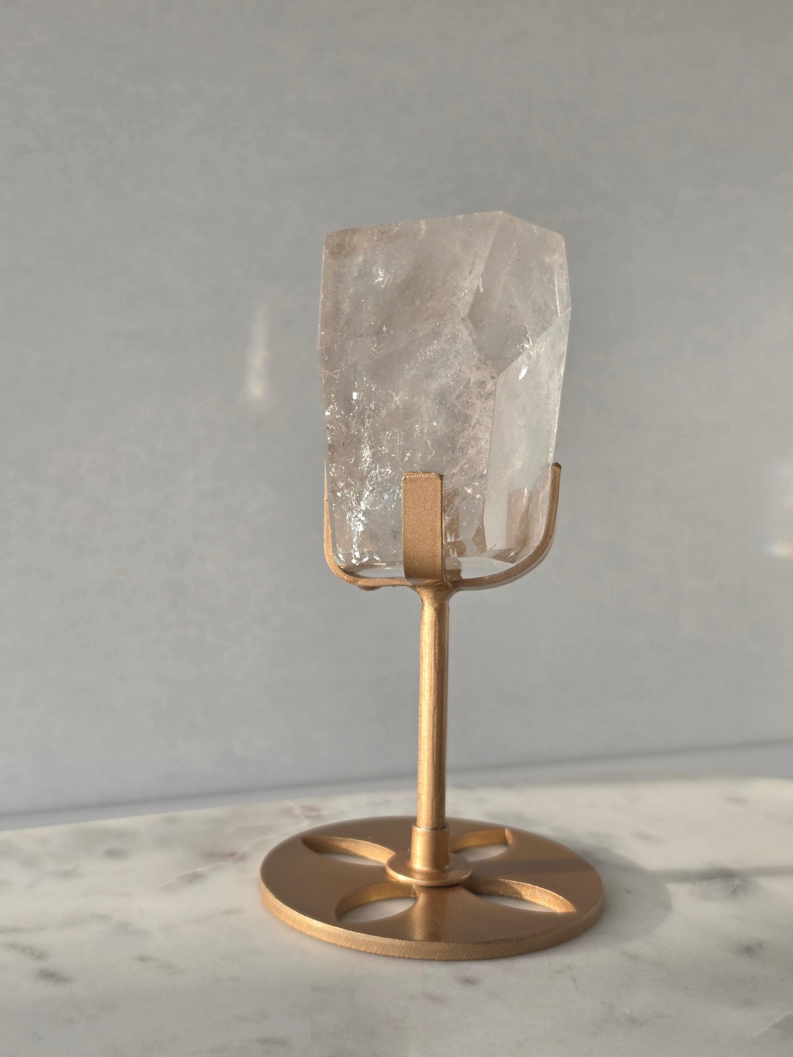 Clear Quartz freeform crystal with subtle smoky-grey translucence, natural internal inclusions and luminous clarity, displayed on an elegant gold-finished stand.