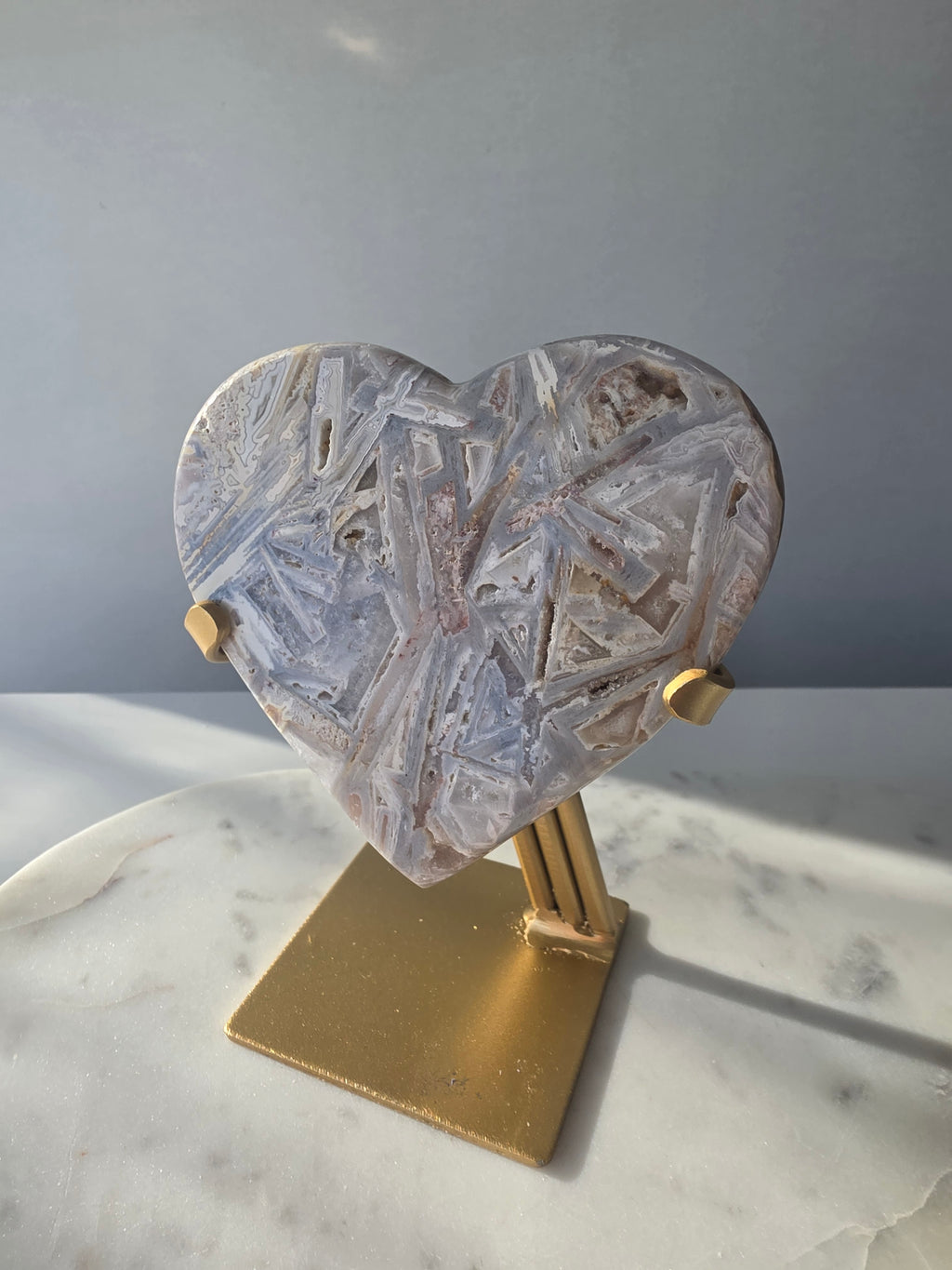 Brazilian Pink Amethyst heart on gold stand featuring intricate white palhetados splinter-like formations, soft blush pink colouring and natural mineral inclusions