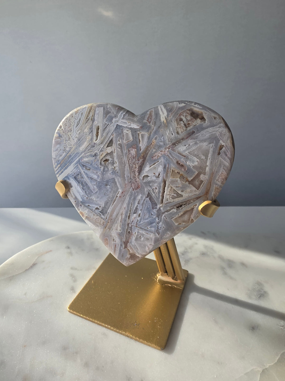 Brazilian Pink Amethyst heart on gold stand featuring intricate white palhetados splinter-like formations, soft blush pink colouring and natural mineral inclusions