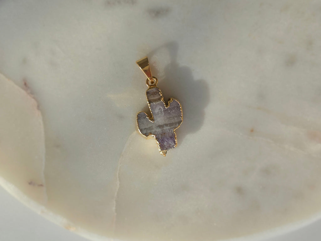Amethyst and agate cactus slice pendant featuring agate banding, purple crystal formations and a 24K gold-plated outline.