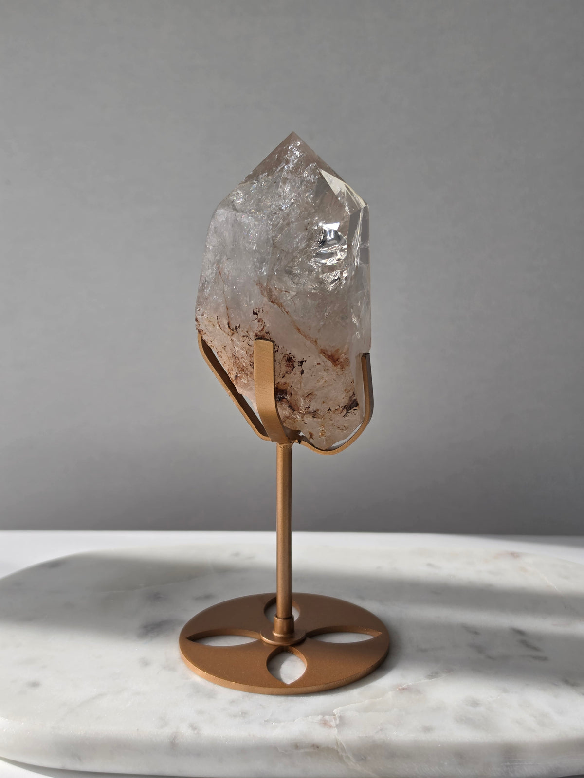 High-grade Nepalese Pink Himalayan Quartz statement piece, 606g and 19cm tall, featuring delicate pink tones, translucent crystal formations and natural inclusions, displayed on a gold stand.
