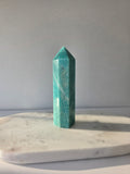 Natural Amazonite tower in soft mint and sea-green tones with subtle blue-green variations, polished geometric point and delicate natural inclusions, displayed as a luxury crystal statement piece.