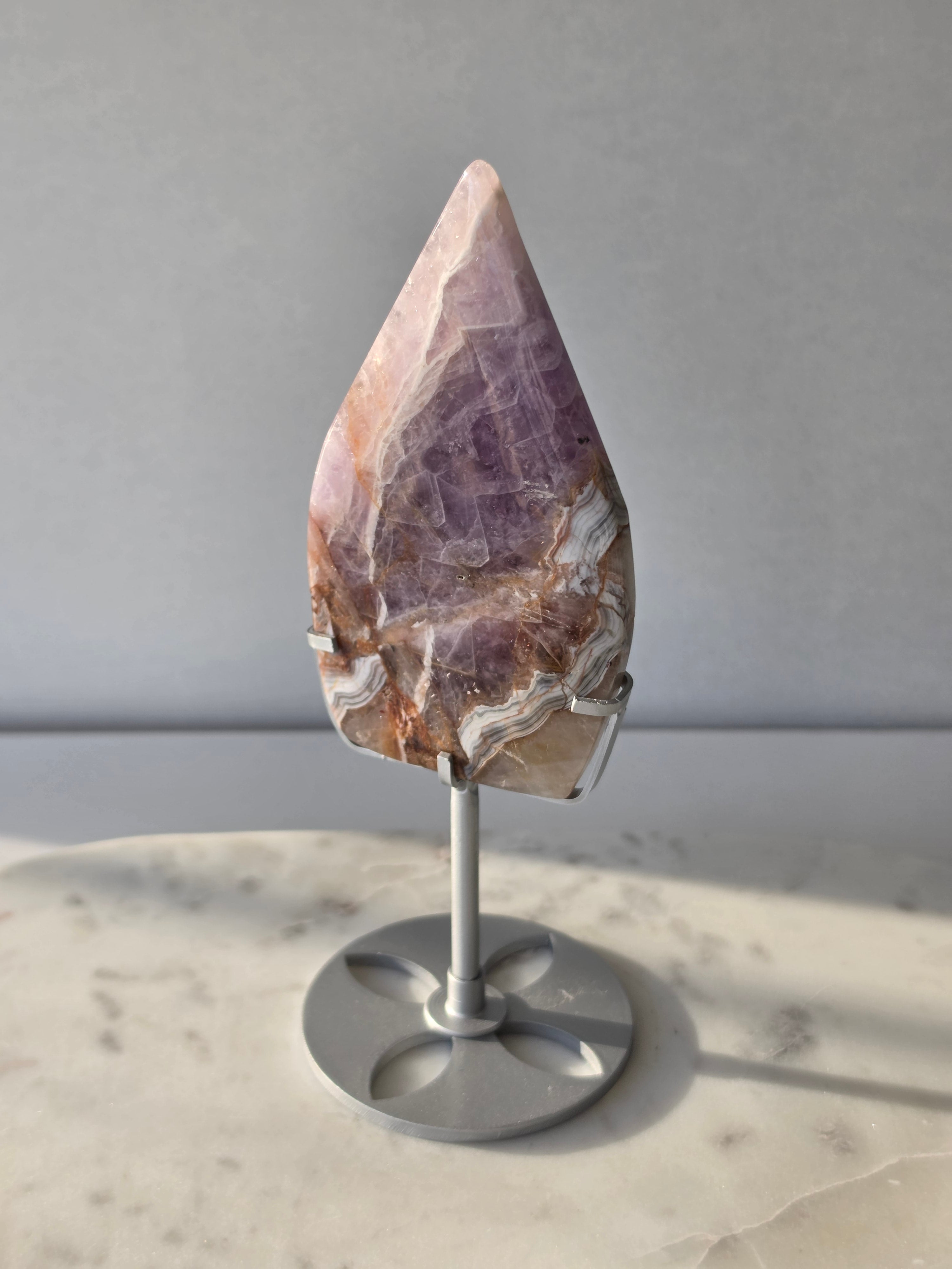 Amethyst Lace Agate flame on a silver stand featuring soft lavender, lilac and creamy white natural banding and intricate lace-like patterns, luxury crystal décor.