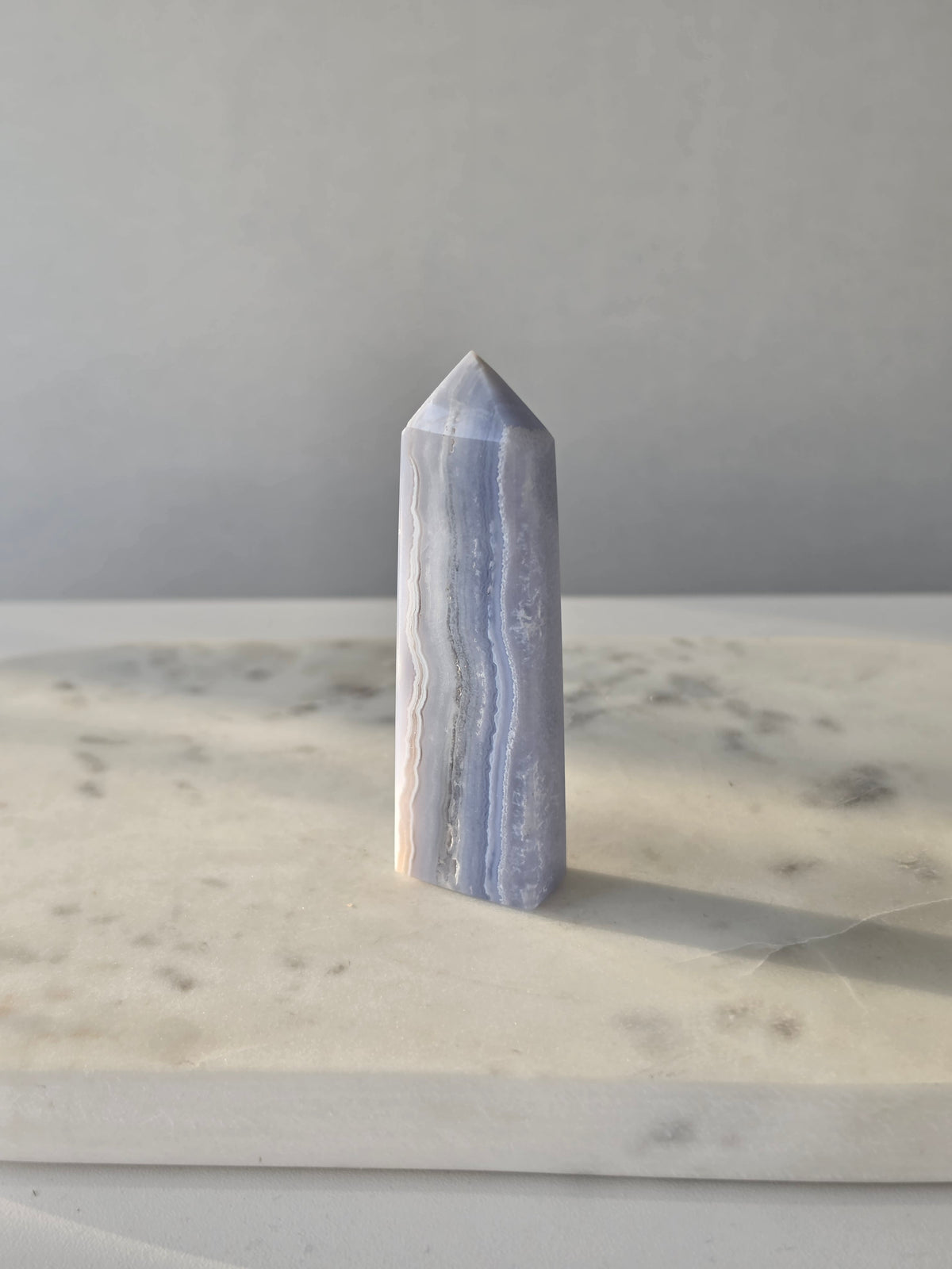 Natural Blue Lace Agate crystal point with soft blue and white banding, polished finish and unique natural formations