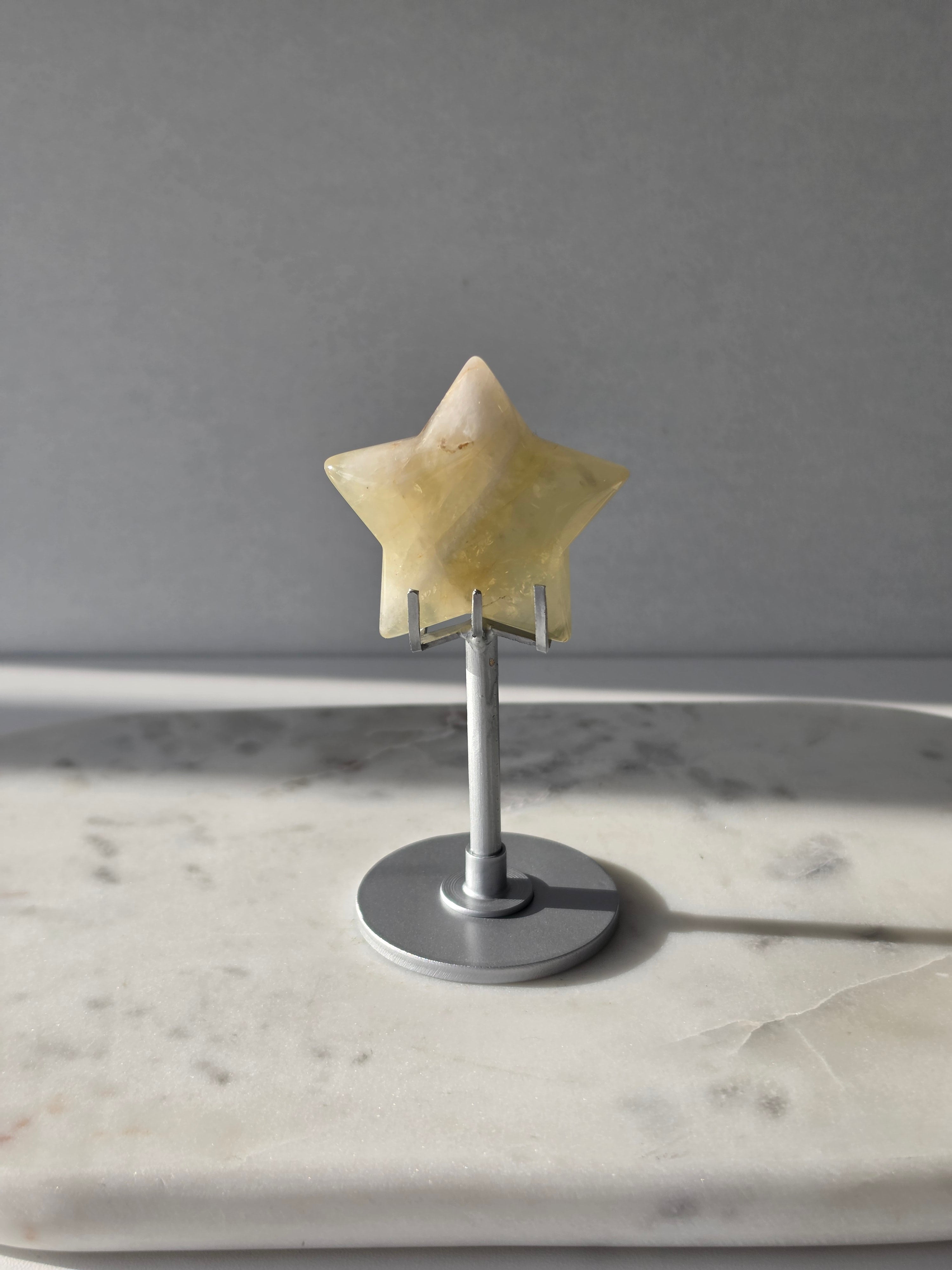 Natural citrine crystal star on a silver stand, featuring translucent golden tones and unique crystal formations, Stone & Bloom statement decor