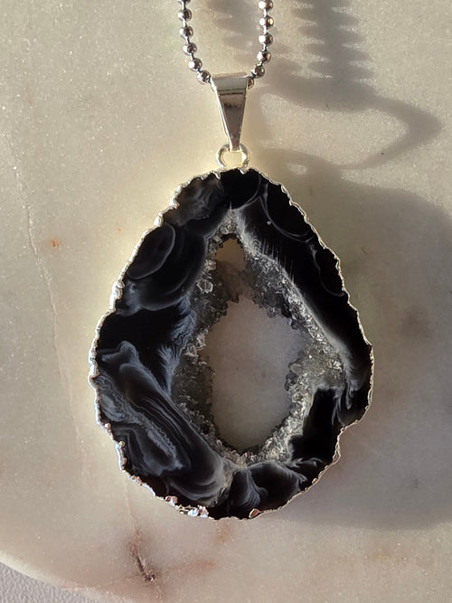 "Brazilian Agate Geode Slice Pendant in natural [brown/black/grey] tones on a silver plated chain with sparkling druzy crystal formations"