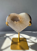 High Clarity Druzy Agate Geode Heart on a gold stand featuring sparkling druzy quartz crystals and natural champagne, caramel, ivory, taupe and smoky-grey agate banding.