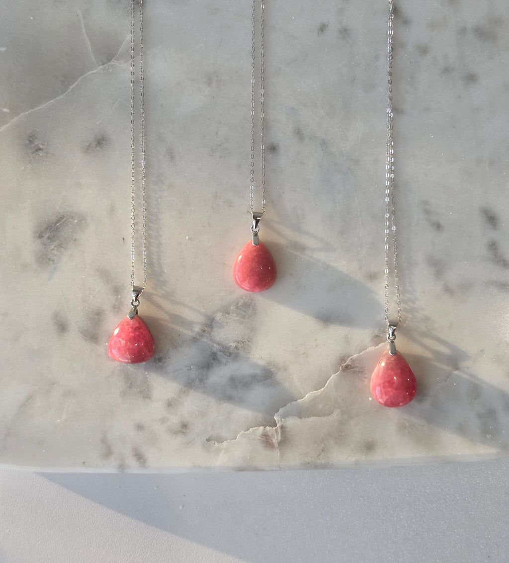 Natural Rhodochrosite teardrop pendant in 925 sterling silver with matching silver chain, featuring vibrant pink tones and unique natural patterns