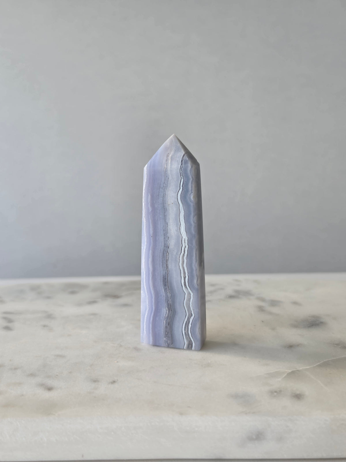 Natural Blue Lace Agate crystal point with soft blue and white banding, polished finish and unique natural formations