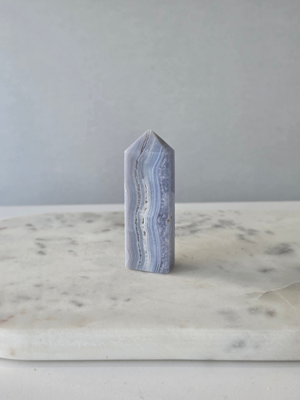 Natural Blue Lace Agate crystal point with soft blue and white banding, polished finish and unique natural formations