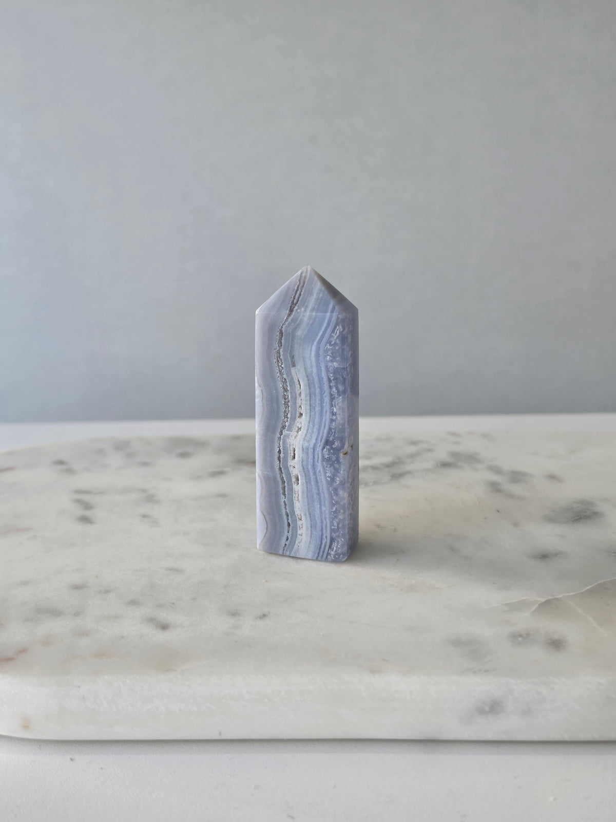 Natural Blue Lace Agate crystal point with soft blue and white banding, polished finish and unique natural formations