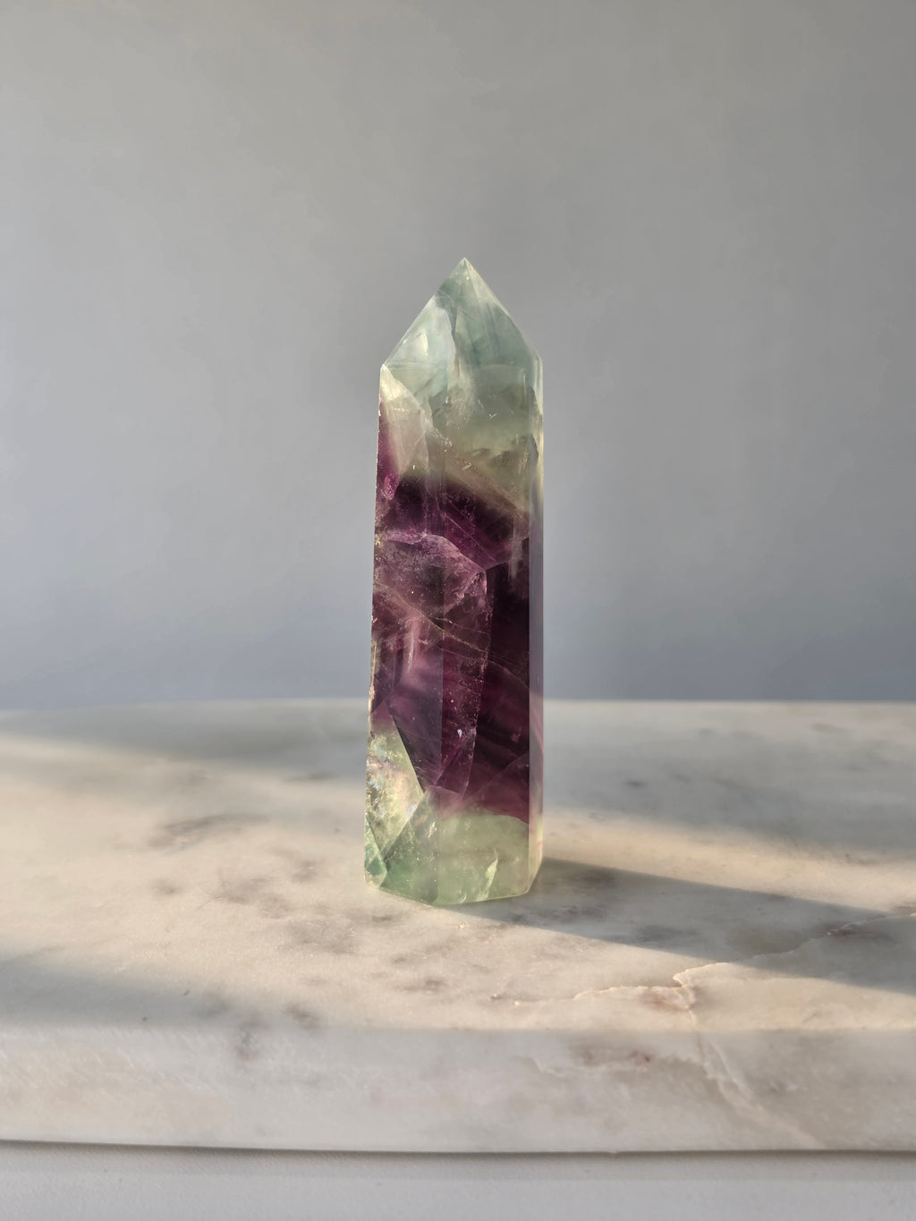Natural Fluorite crystal point with deep purple and light green colour zoning, transparent polished finish and unique internal formations