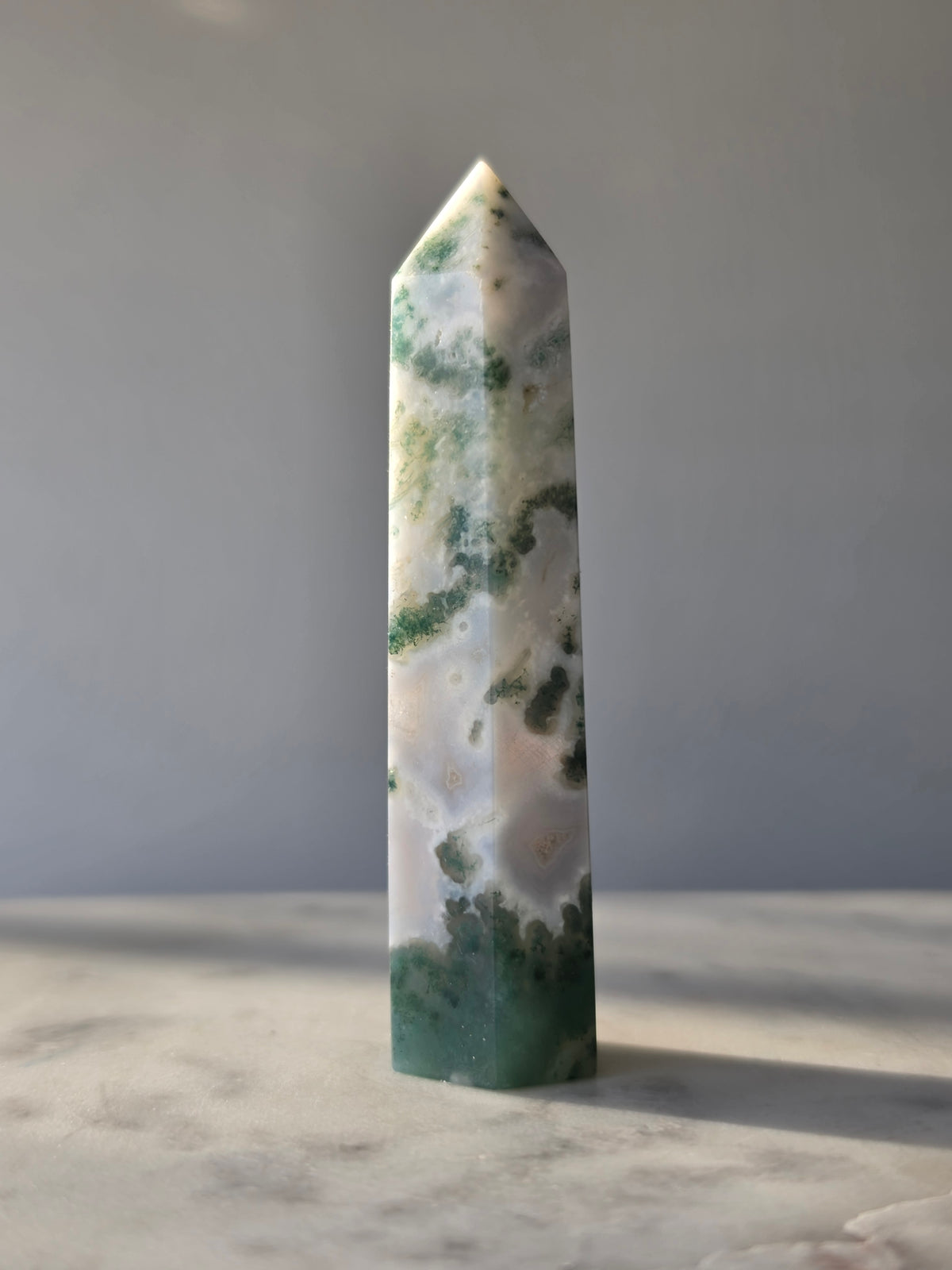 Natural Moss Agate crystal point with forest green moss-like inclusions on a milky white translucent base
