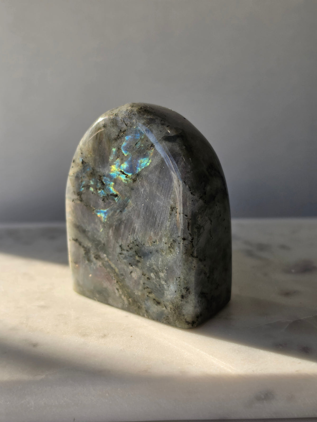 353g polished Labradorite cut base featuring vivid blue, turquoise and golden-green iridescent flashes across a smoky grey and charcoal natural stone.